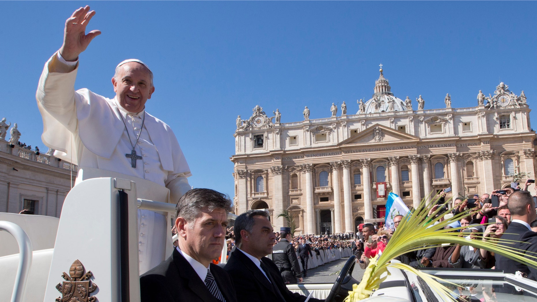 Pope Francis blesses the crowd as he leaves after a Palm Sunday Mass he celebrated in St. Peter's Square, at the Vatican, Sunday, March 29, 2015. Pope Francis walked solemnly through St. Peter's Square in a Palm Sunday procession to usher in Holy Week ahead of Easter. (AP Photo/Andrew Medichini)