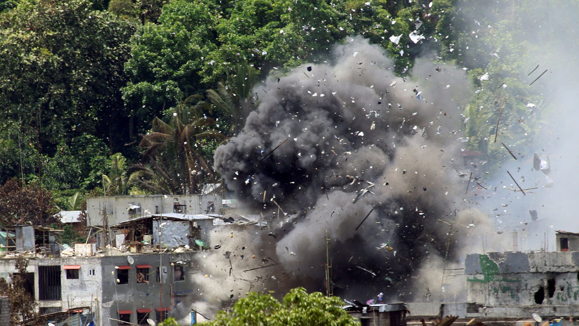 June 20: Debris and smoke are seen after an OV-10 Bronco aircraft released a bomb during an airstrike, as government forces continue their assault against insurgents from the Maute group, who have taken over large parts of Marawi City.