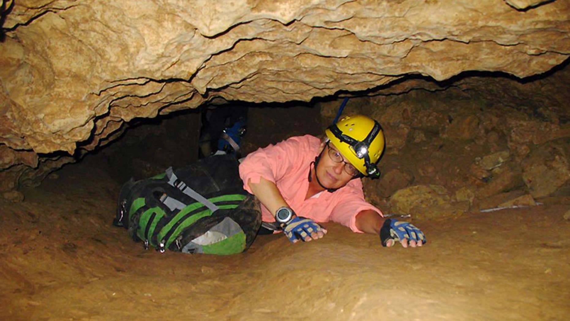 FILE - In this July 3, 2008, file photo, New Mexico Tech professor Penny Boston crawls through the Mud Turtle Passage on the way to the Snowy River formation during an expedition in Fort Stanton Cave, N.M. Boston, who discovered extreme life in New Mexico caves in 2008, presented new findings on Friday, Feb. 17, 2017 of microbes trapped in crystals in Mexico that could be 50,000 years old. (AP Photo/Susan Montoya Bryan)