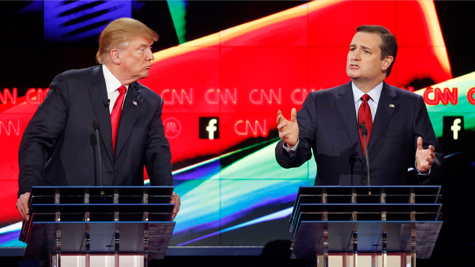 In this Dec. 15, 2015 photo, Donald Trump, left, watches as Ted Cruz speaks during the CNN Republican presidential debate at the Venetian Hotel & Casino in Las Vegas. A growing debate over Americaâs role in promoting regime change in the Middle East is creating unusual alliances among 2016 presidential candidates that cross party lines. (AP Photo/John Locher)