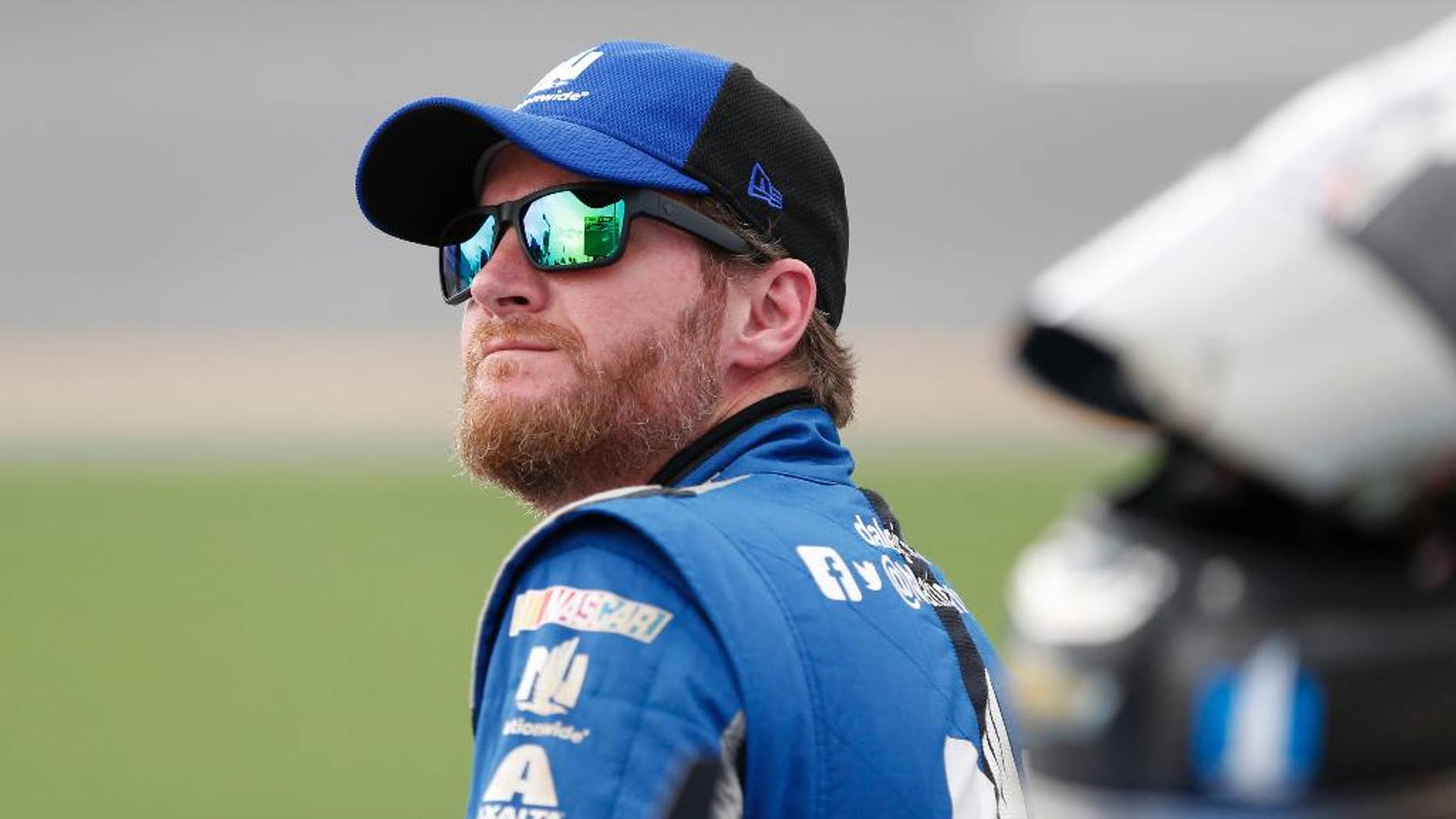 File-This July 1, 2016, file photo shows Dale Earnhardt Jr. watching the leader-board during qualifying for a NASCAR Sprint Cup auto race at Daytona International Speedway in Daytona Beach, Fla. Earnhardt Jr. says his concussion-like symptoms haven't changed and his return to NASCAR doesn't appear imminent. NASCAR's most popular driver is scheduled to miss his third consecutive race Sunday because he suffers from symptoms of a concussion. Earnhardt tweeted Saturday, July 30, 2016, there was no change in his condition. (AP Photo/Wilfredo Lee, File)