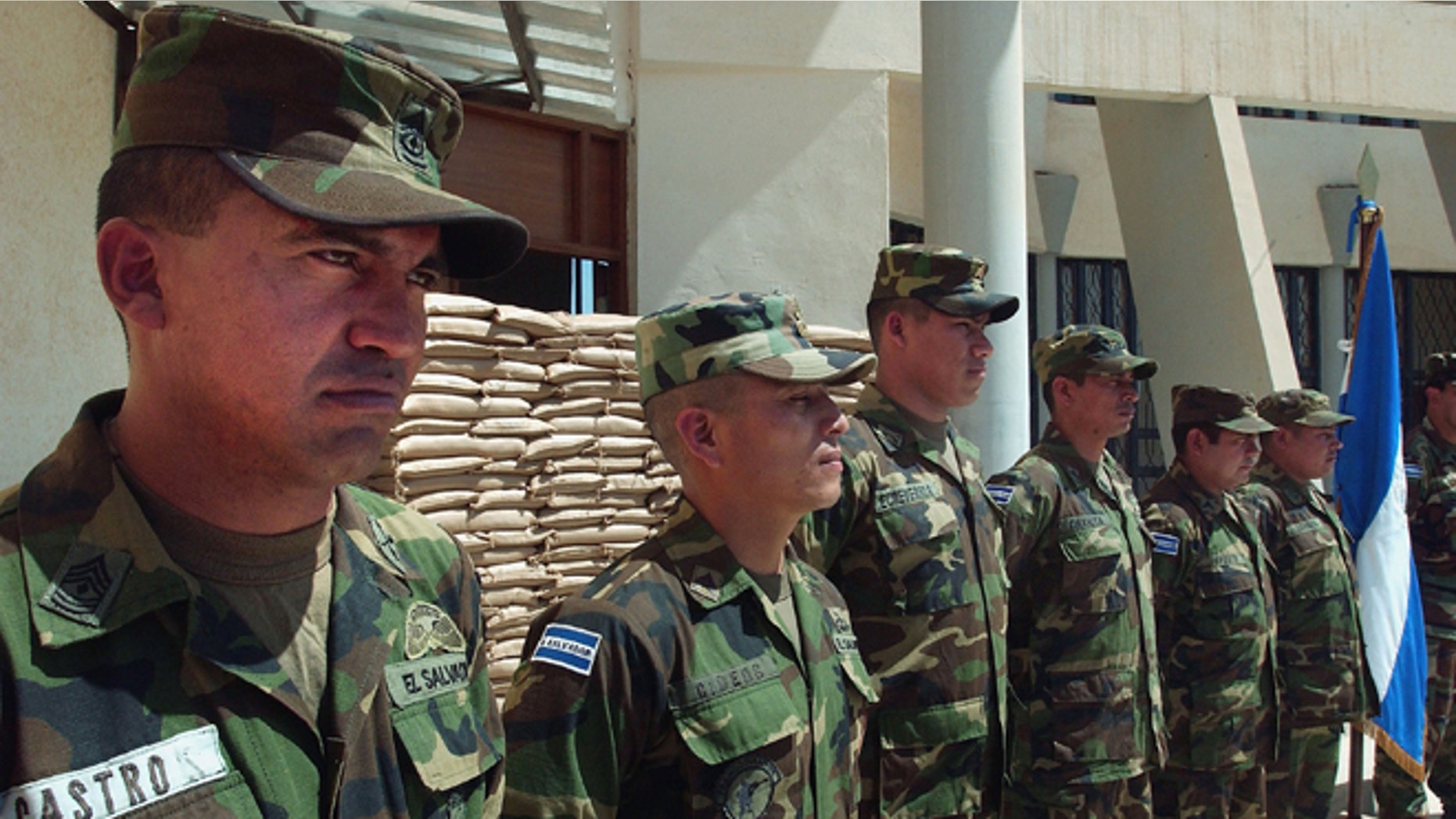AN NAJAF, IRAQ - MARCH 23: An El Salvadoran military unit stands at attention prior to a visit by Chief American Coalition Provisional Authority Administrator J. Paul Bremer March 23,2004 to thank them in in Najaf, Iraq. The unit fought off an small arms and rpg attack on a CPA convoy recently between Hilla and Najaf. Bremer participated in a series of press events today designed to mark the beginning of the 100 Day countdown to the handover of power back to Iraqis scheduled for June 30, 2004. In addition to congratulating the El Salvadoran military unit, Bremer also visited the Najaf power plant, and conducted a town hall style meeting in Najaf with local clerics, politicians, and security officials (Pool/Photo by Scott Nelson/Getty Images) *** Local Caption *** J. Paul Bremer