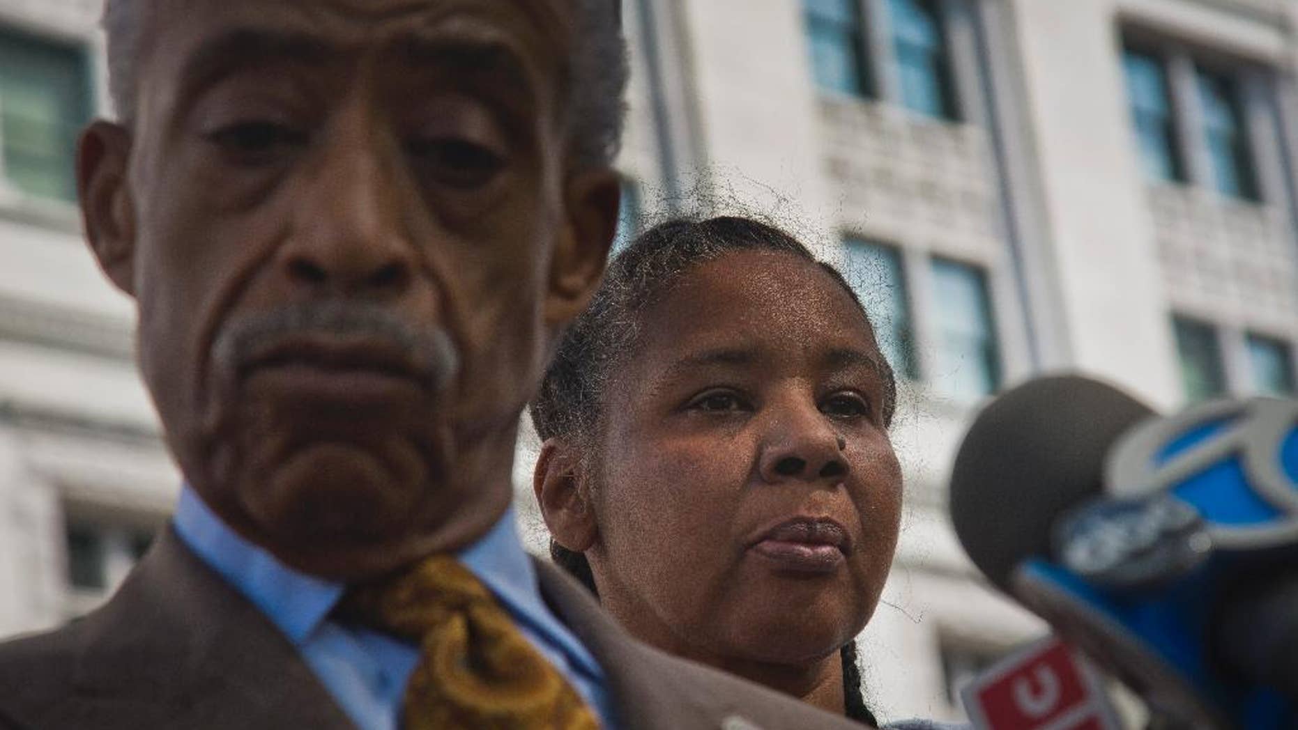 Rev. Al Sharpton, left, and Esaw Garner, the wife of fatal police chokehold victim Eric Garner, listen during a press briefing after meeting privately with U.S. Attorney Loretta Lynch on Thursday Aug. 21, 2014 in New York. The family of the unarmed Eric Garner, whose death last month in police custody was recorded on video, has asked federal prosecutors to investigate the case.(AP Photo/Bebeto Matthews)