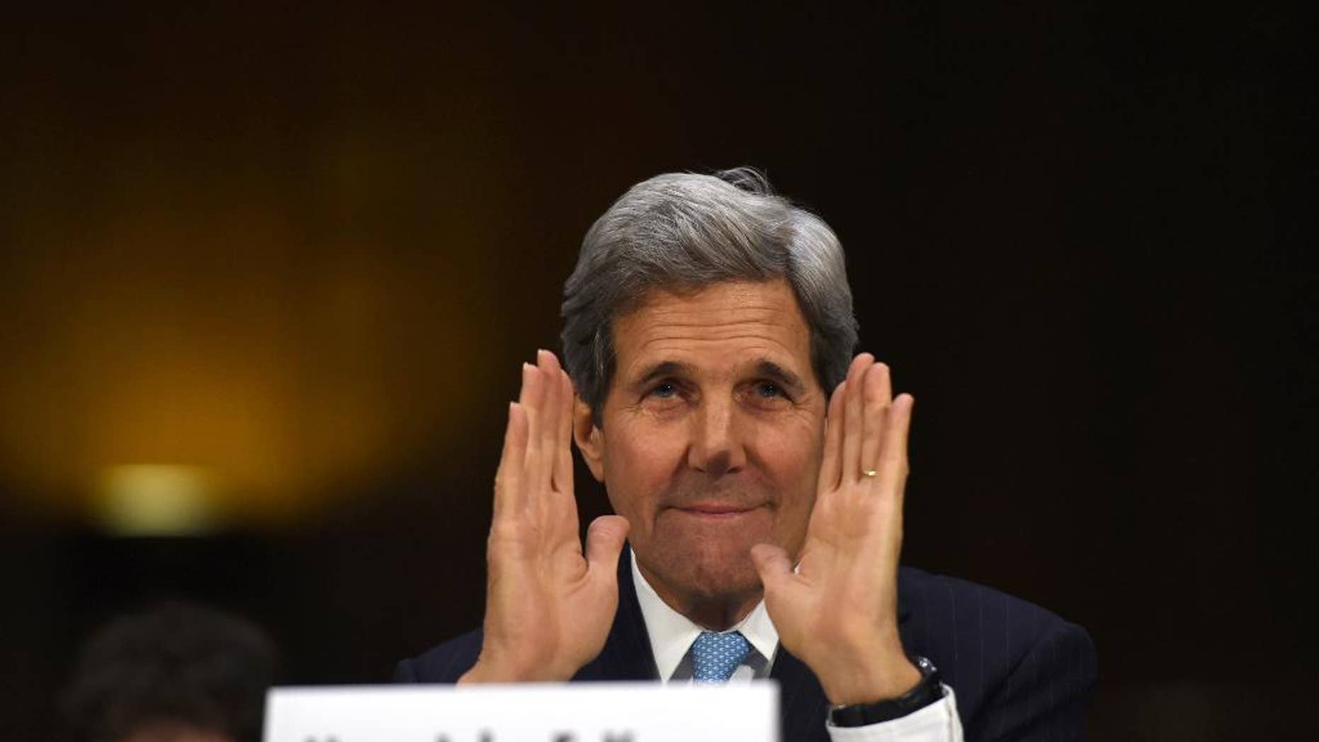 Secretary of State John Kerry greets committee members as he arrives on Capitol Hill in Washington, Tuesday, Dec. 9, 2014, to testify before the Senate Foreign Relations hearing on "Authorization for the Use of Military Force Against IS." (AP Photo/Molly Riley)