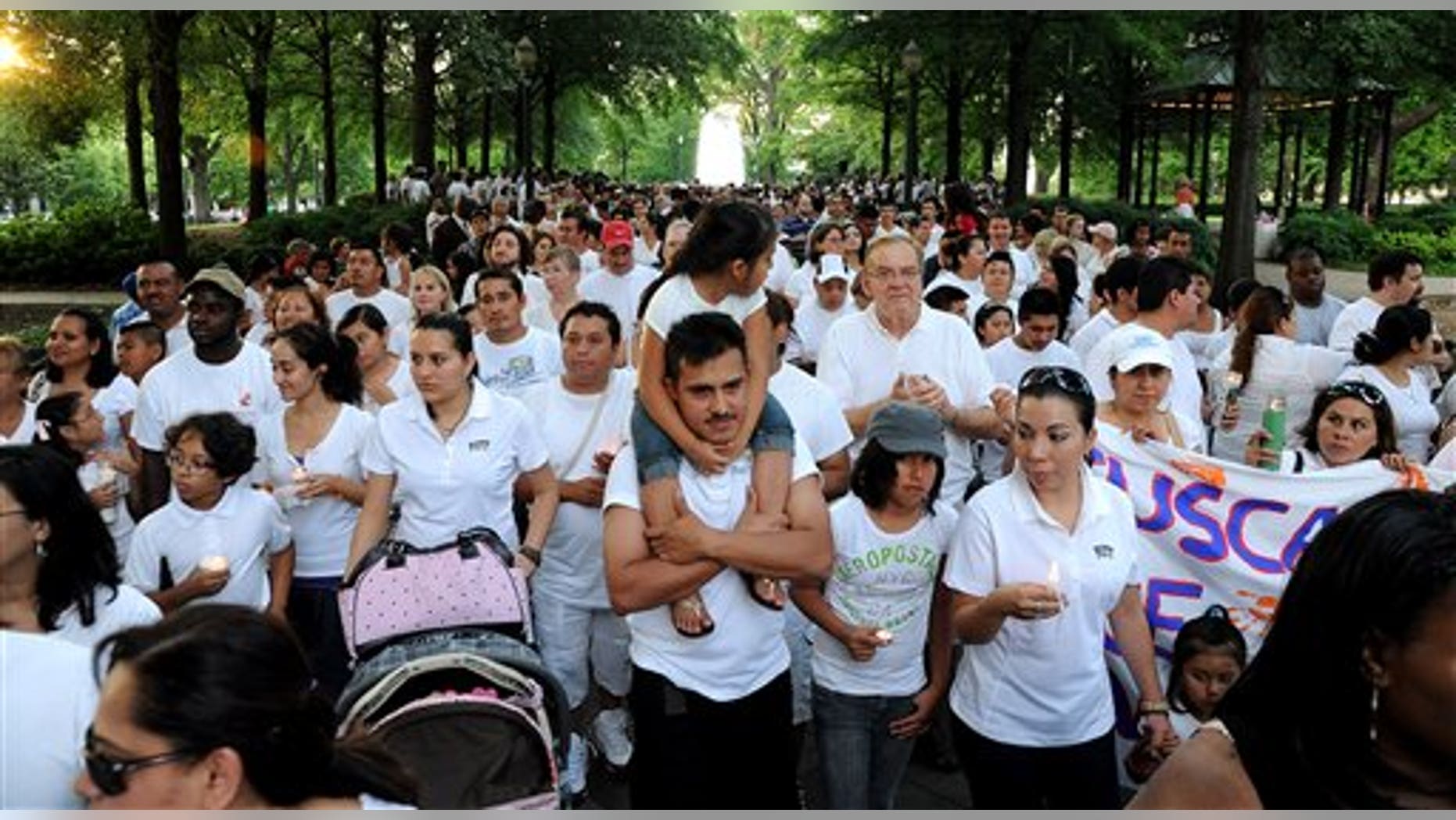 Participants in a protest against Alabama's new law against illegal immigration march through Linn Park, Saturday, June 25, 2011, in Birmingham, Ala. The new law takes effect Sept. 1, 2011, and makes it a crime to knowingly hire illegal immigrants, rent them places to live or give them rides. It also requires schools to determine the immigration status of their students and report it to the state, although children in the country illegally would not be refused enrollment. MAGS OUT (AP Photo/ The Birmingham News, Mark Almond)