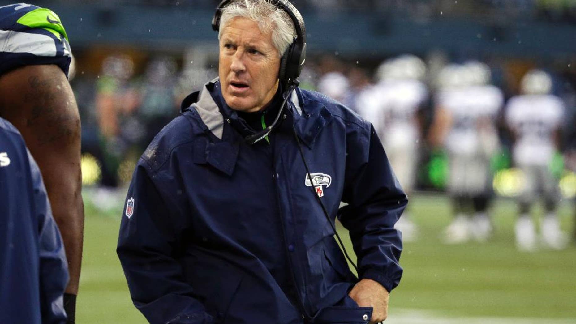 Seattle Seahawks head coach Pete Carroll wears a headset as he walks on the sideline during the second half of an NFL football game against the Oakland Raiders, Sunday, Nov. 2, 2014, in Seattle. (AP Photo/Elaine Thompson)
