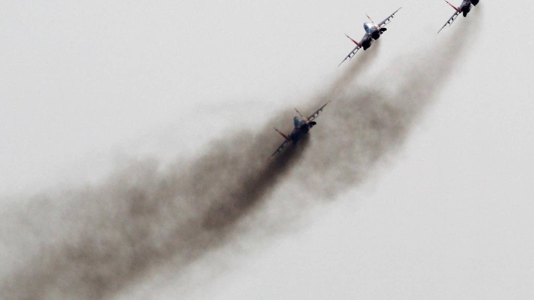 FILE - In this Sept 1, 2012 file photo, a Mig-29 jet fighters of Russian aerobatic team Strizhi (Swifts) perform during air-show in Batajnica, military airport near Belgrade, Serbia. NATO is holding an emergency exercise drill in Montenegro while Russia's troops will participate in a war game in Serbia as the two Balkans neighbors that seem to be heading different directions strategically. (AP Photo/Darko Vojinovic, File)