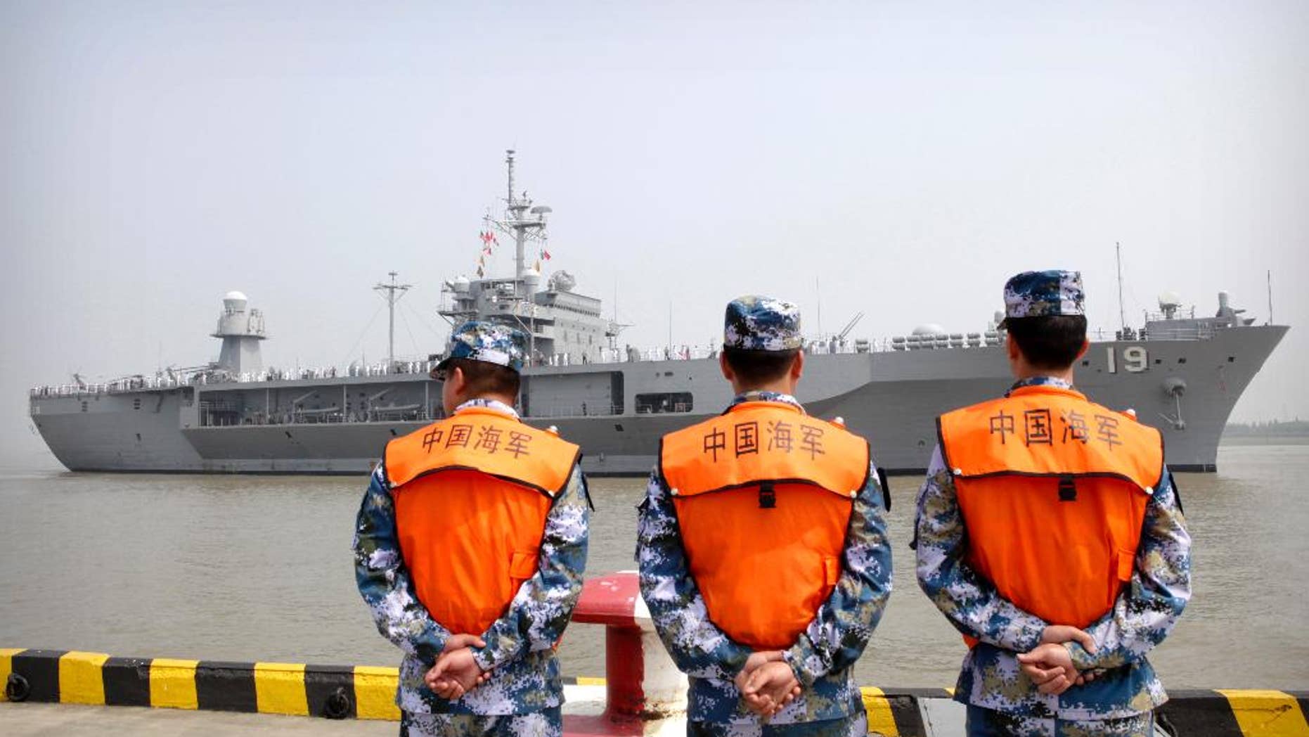 FILE - In this May 6, 2016, file photo, soldiers from the Chinese People's Liberation Army (PLA) Navy watch as the USS Blue Ridge arrives at a port in Shanghai. Seeking to calm escalating tensions in the South China Sea, top generals from China and the U.S. spoke by phone Thursday, May 12, 2016, and said they were ready to work out an effective mechanism to prevent confrontation and maintain stability in the region. (AP Photo, File)