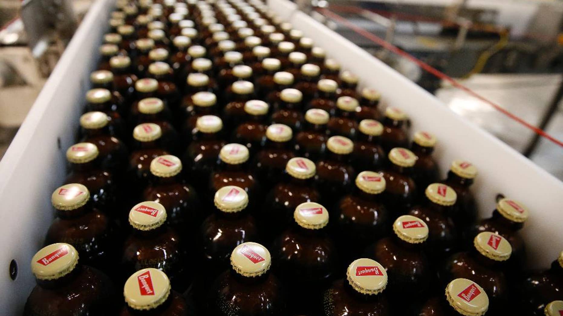 In this March 11, 2015 photo, newly-filled and sealed bottles of Coors Banquet beer move along on a conveyor belt, at the MillerCoors Brewery, in Golden, Colo. The Commerce Department releases factory orders for March on Monday, May 4, 2015. (AP Photo/Brennan Linsley)
