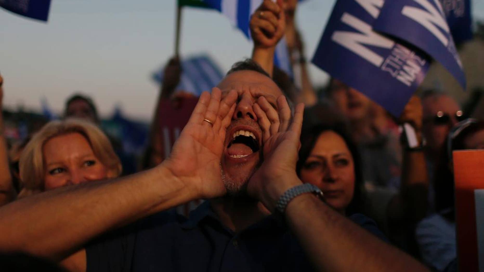 A demonstrator shouts slogans during a rally organized by supporters of the Yes vote in Athens, Friday, July 3, 2015. A new opinion poll shows a dead heat in Greece's referendum campaign with just two days to go before Sunday's vote on whether Greeks should accept more austerity in return for bailout loans. (AP Photo/Emilio Morenatti)