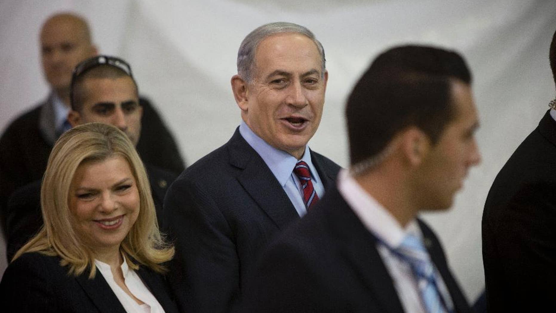 FILE - In this Wednesday, Dec. 31, 2014 file photo, Israeli Prime Minister Benjamin Netanyahu and his wife Sarah arrive for the Likud party primary elections in Jerusalem. Israel's attorney general has ordered a criminal investigation into excessive spending at Netanyahu's residences. The announcement followed a report by the state comptroller, an official watchdog body, that cited large sums of public money spent on food, furniture, cleaning and gardening at Netanyahu and his wife's official residence in Jerusalem and their private home in the exclusive coastal city of Caesarea. (AP Photo/Oded Balilty, File)