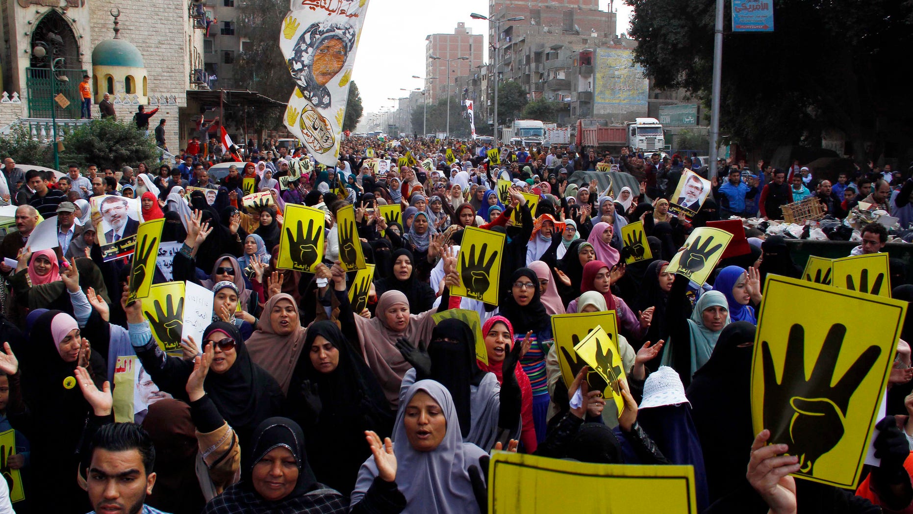 Supporters of ousted President Mohammed Morsi show their symbolic sign of four fingers to commemorate the protesters killed and injured during the Aug. 14 dispersal while marching on a street in Cairo, Egypt, Friday, Feb. 14, 2014. Morsi supporters had camped out in two locations in Cairo for nearly two months before police moved in to break up the sit-in encampments on Aug. 14 last year, killing at least 600. (AP Photo/El Shorouk newspaper, Ahmed Abdel Fattah) EGYPT OUT