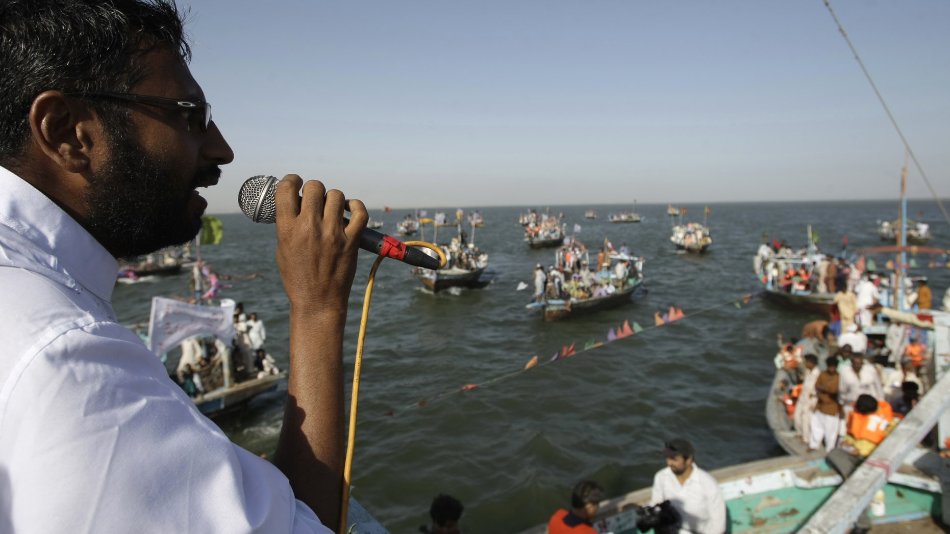 Pakistani election candidate Usman Ghani addresses fishermen living in his constituency during a campaign in the Arabian Sea near the coastal area of Karachi, Pakistan on Friday, May 3, 2013. Pakistan is scheduled to hold parliamentary elections on May 11, the first transition between democratically elected governments in a country that has experienced three military coups and constant political instability since its creation in 1947. (AP Photo/Fareed Khan)