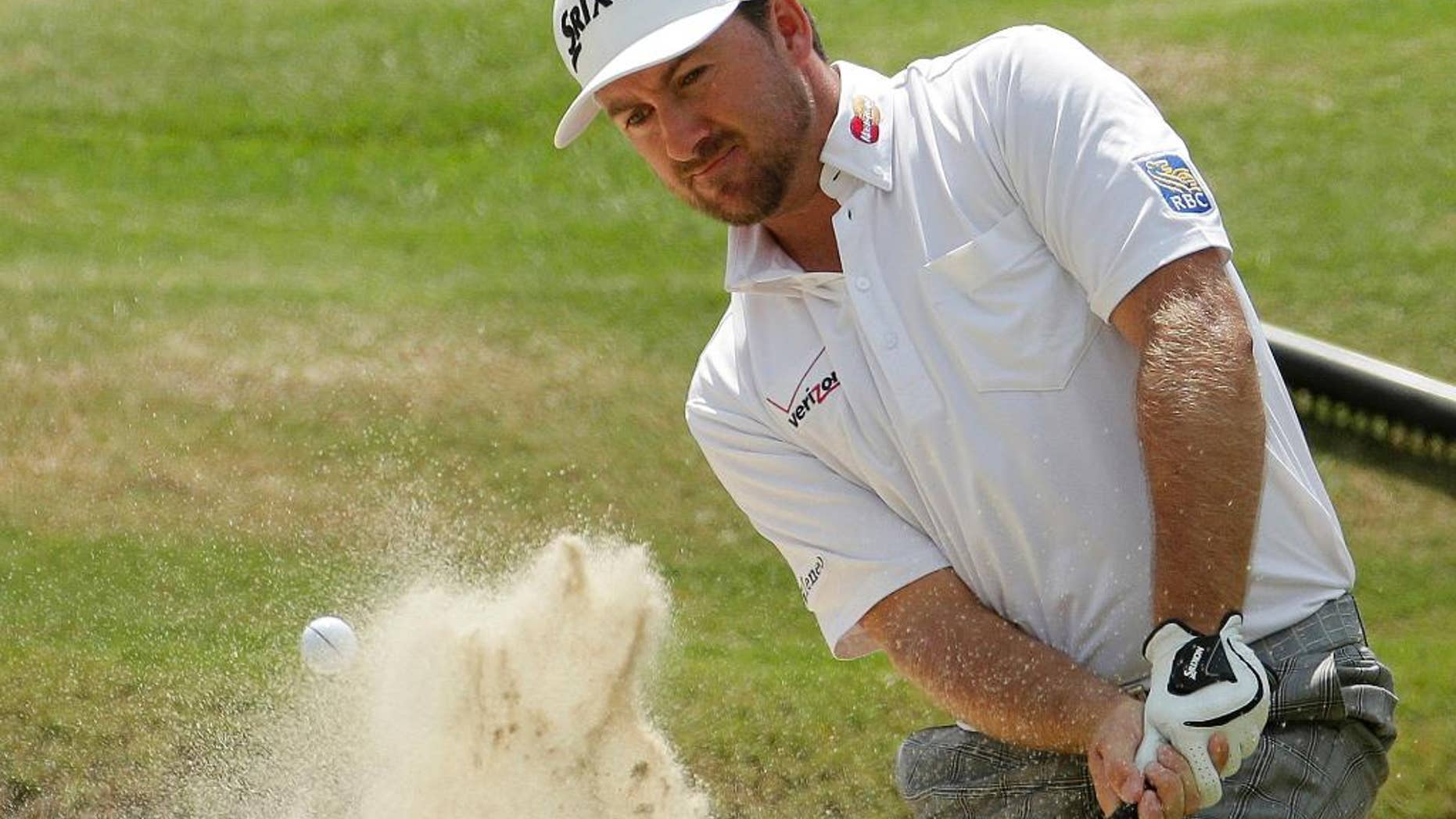 FILE - In this June 13, 2014, file photo, Graeme McDowell, of Northern Ireland, hit out of the bunker on the 16th hole during the second round of the U.S. Open golf tournament in Pinehurst, N.C. McDowell is basking in his latest title: Daddy. A father for all of eight days, McDowell returned to the golf course this week to refocus on his day job, which includes a shot at $10 million. (AP Photo/Charlie Riedel, File)