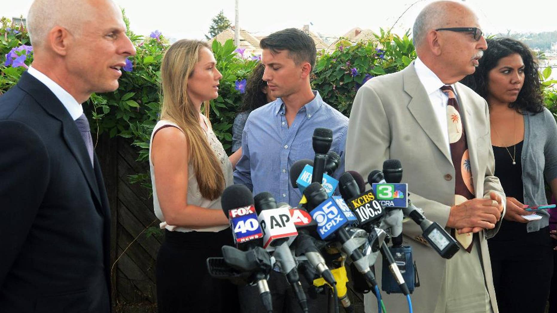 Denise Huskins, second from left, and her boyfriend, Aaron Quinn, turn to each other at the end of a news conference on Monday, July 13, 2015, in Vallejo, Calif. At left is Huskins' attorney, Douglas Rappaport and second from right is Quinn's attorney, Daniel Russo. The lawyers for the couple in the kidnap-for-ransom case that police called a hoax are blasting investigators and asking that authorities set the record straight. (Mike Jory/Vallejo Times-Herald via AP)