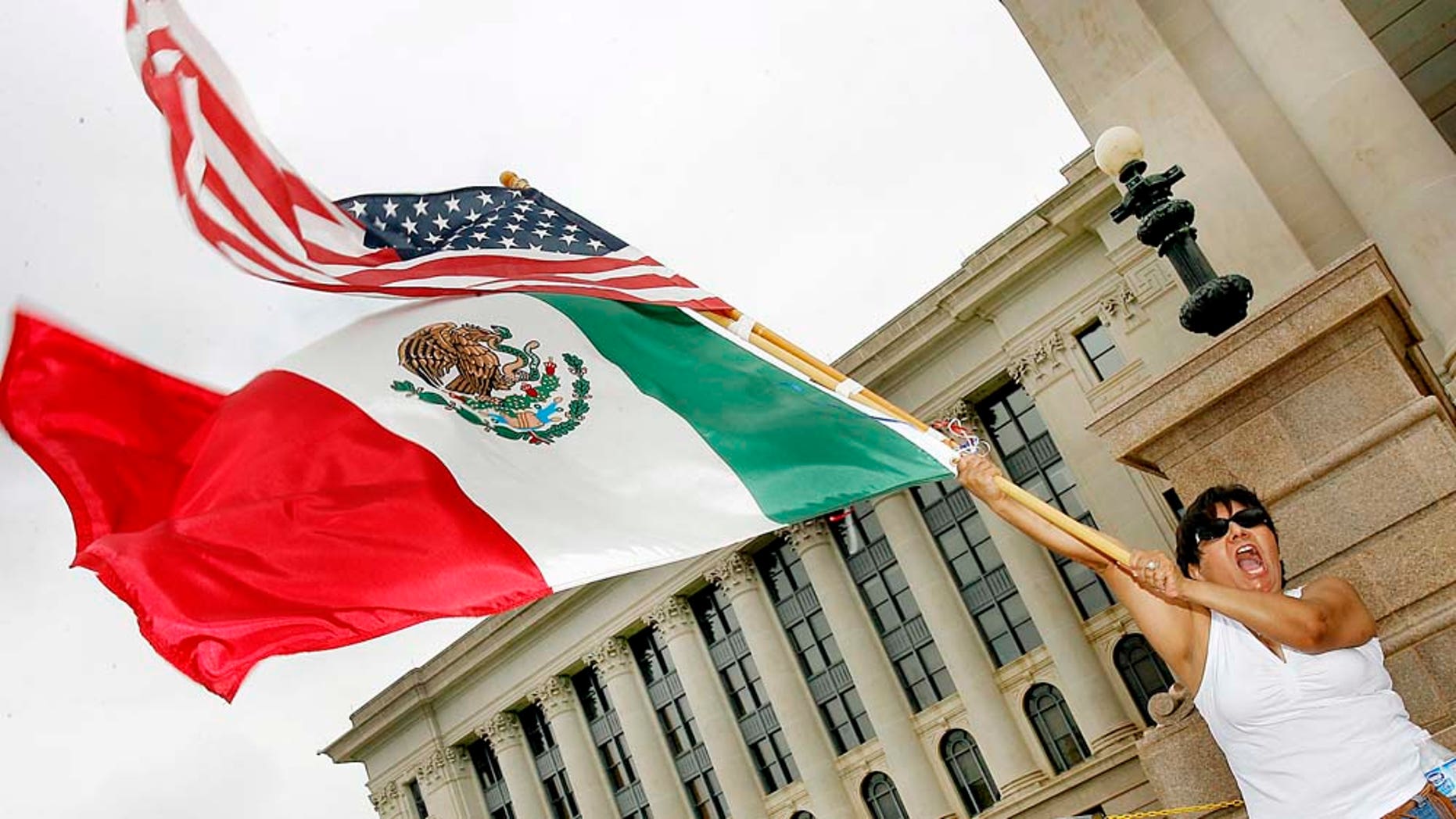FILE - In this April 1, 2006 file photo, Patricia Gracia of Chihuahua, Mexico, waves American and Mexican flags at a Justice and Dignity for All Immigrants rally at the steps of the Oklahoma State Capital in Oklahoma City. New U.S. Census Bureau figures for Oklahoma, released Tuesday, Feb. 15, 2011, show that the state now has more residents who identify themselves as Hispanic than Native American. (AP Photo/Ty Russell, File)