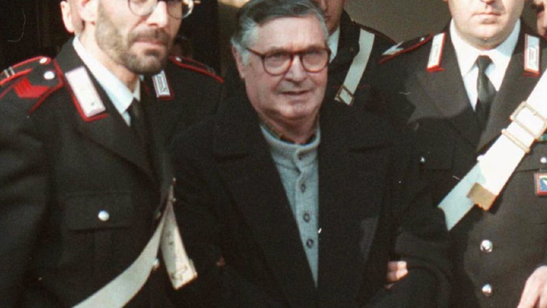 Mafia ″boss of bosses″ Salvatore ″Toto″ Riina, center, enters handcuffed into Bologna’s bunker-courtroom, escorted by Carabinieri, Italian paramiliary police, in Bologna, Italy, in January 1996.