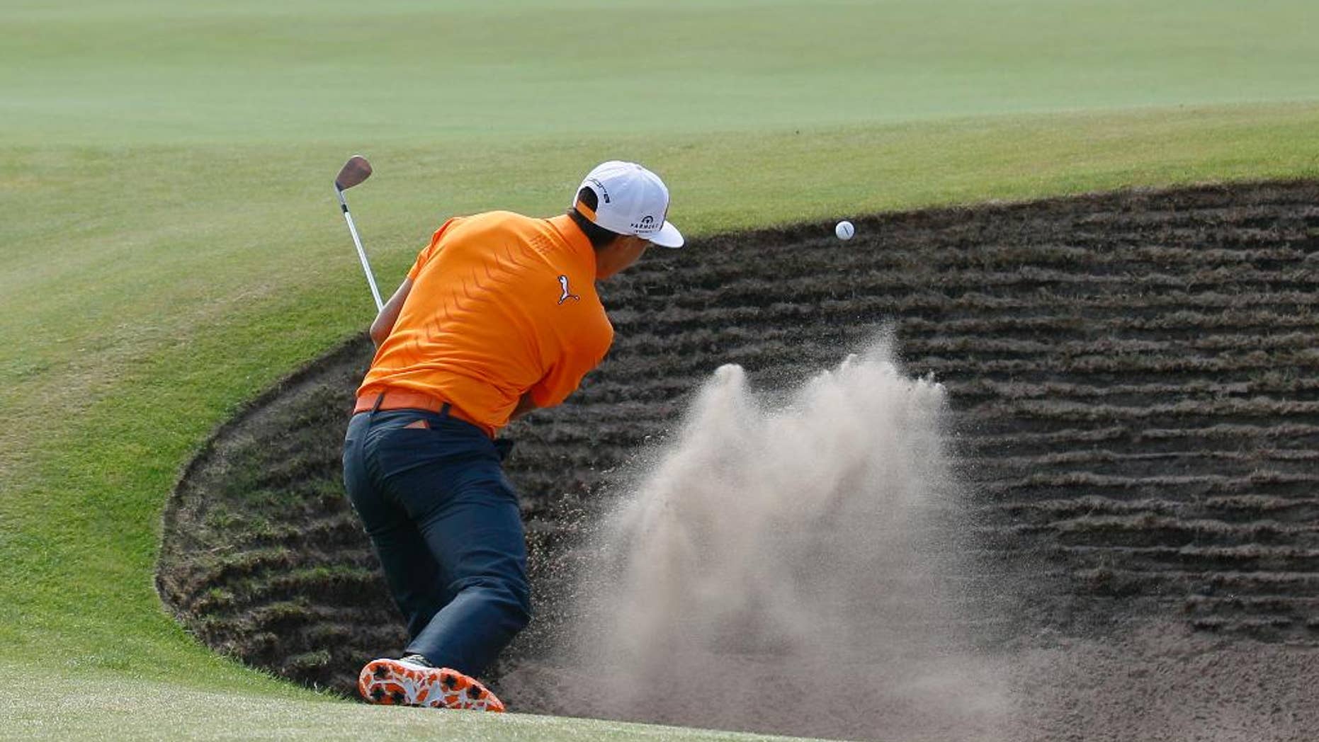Rickie Fowler of the US plays out of a bunker on the 6th green during the final round of the British Open Golf championship at the Royal Liverpool golf club, Hoylake, England, Sunday July 20, 2014. (AP Photo/Peter Morrison)