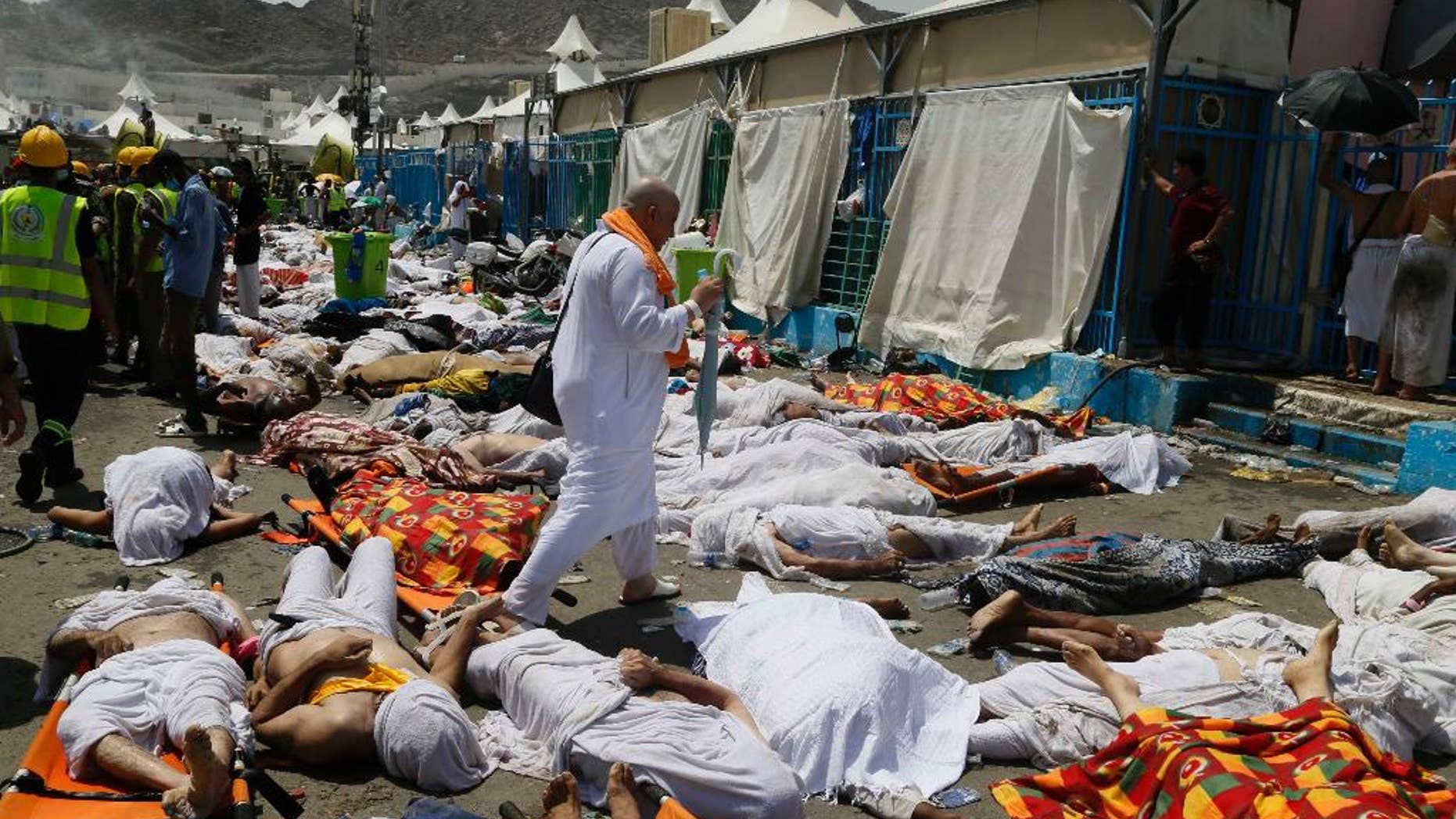 FILE - In this Thursday, Sept. 24, 2015 file photo, a Muslim pilgrim walks through the site where dead bodies are gathered in Mina, Saudi Arabia during the annual hajj pilgrimage. The crush and stampede that struck the hajj last month in Saudi Arabia killed at least 2,121 pilgrims, a new Associated Press tally showed Monday, after officials in the kingdom met to discuss the tragedy. (AP Photo, File)