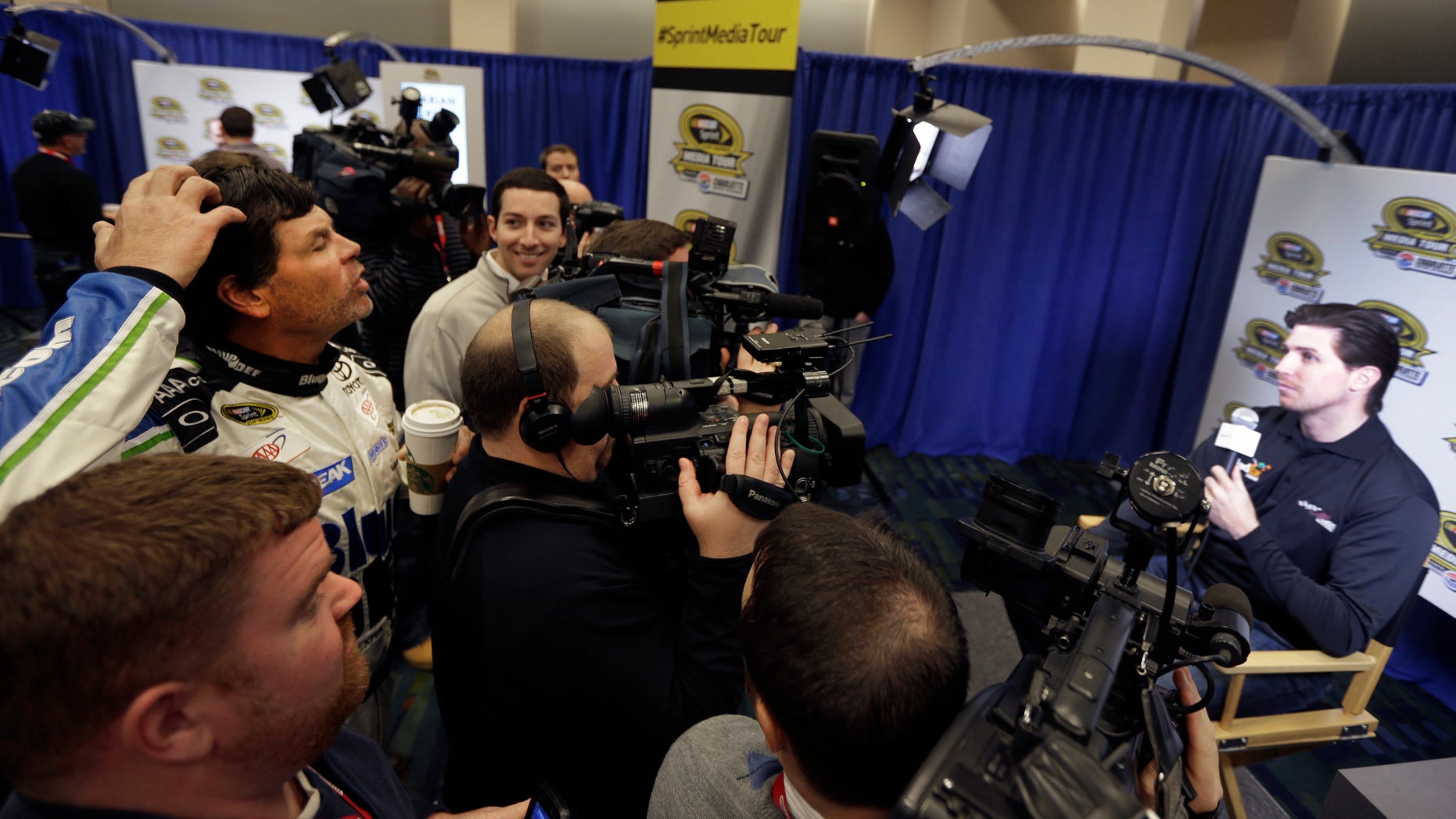 Driver/owner Michael Waltrip, left, jokes with driver Denny Hamlin, right, about his hair during a news conference at the NASCAR Sprint Cup auto racing Media Tour in Charlotte, N.C., Thursday, Jan. 30, 2014. (AP Photo)