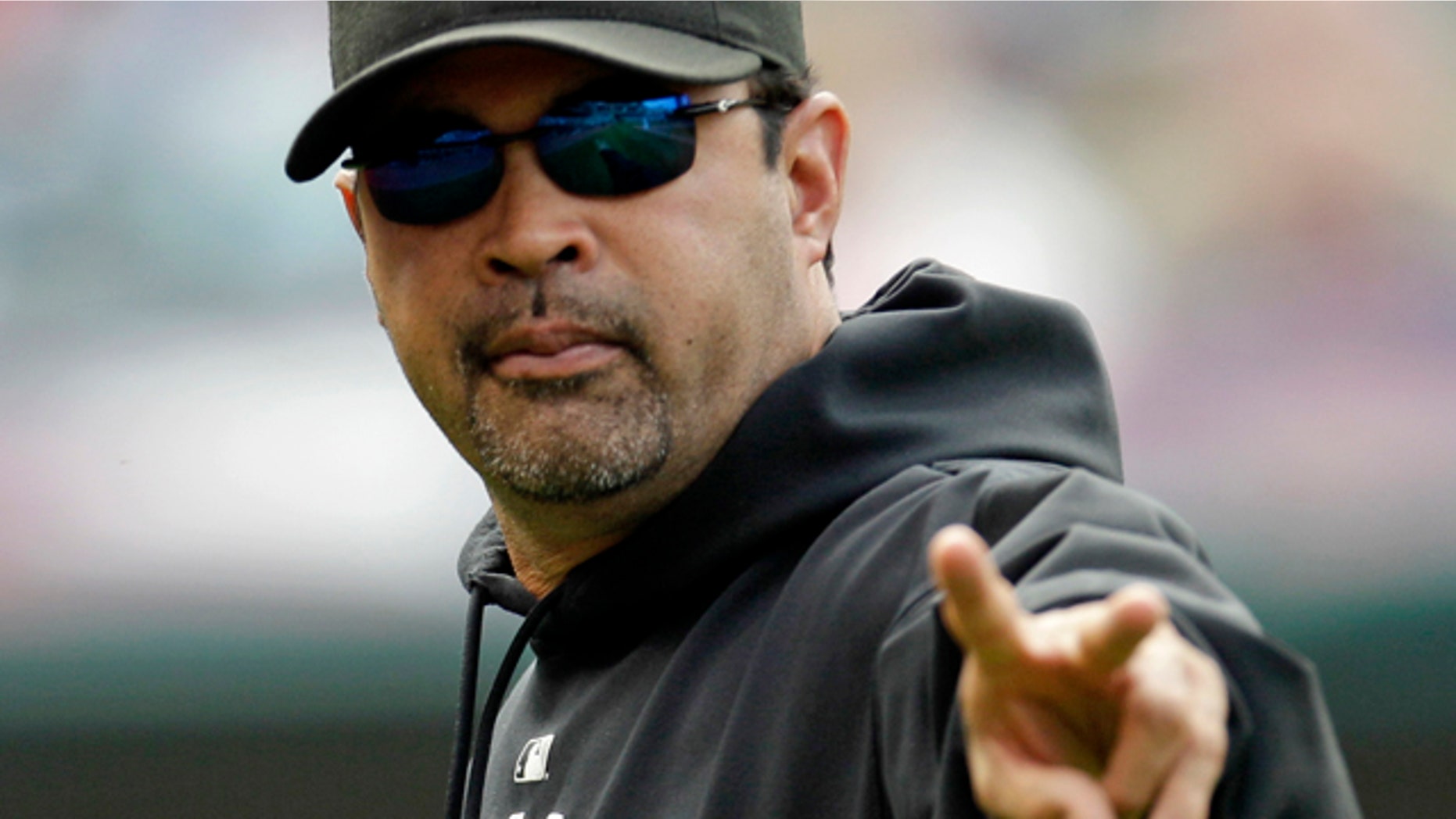 Chicago White Sox manager Ozzie Guillen acknowledges a fan during the seventh inning in the first baseball game of a doubleheader against the Cleveland Indians, Tuesday, Sept. 20, 2011, in Cleveland. (AP Photo/Tony Dejak)
