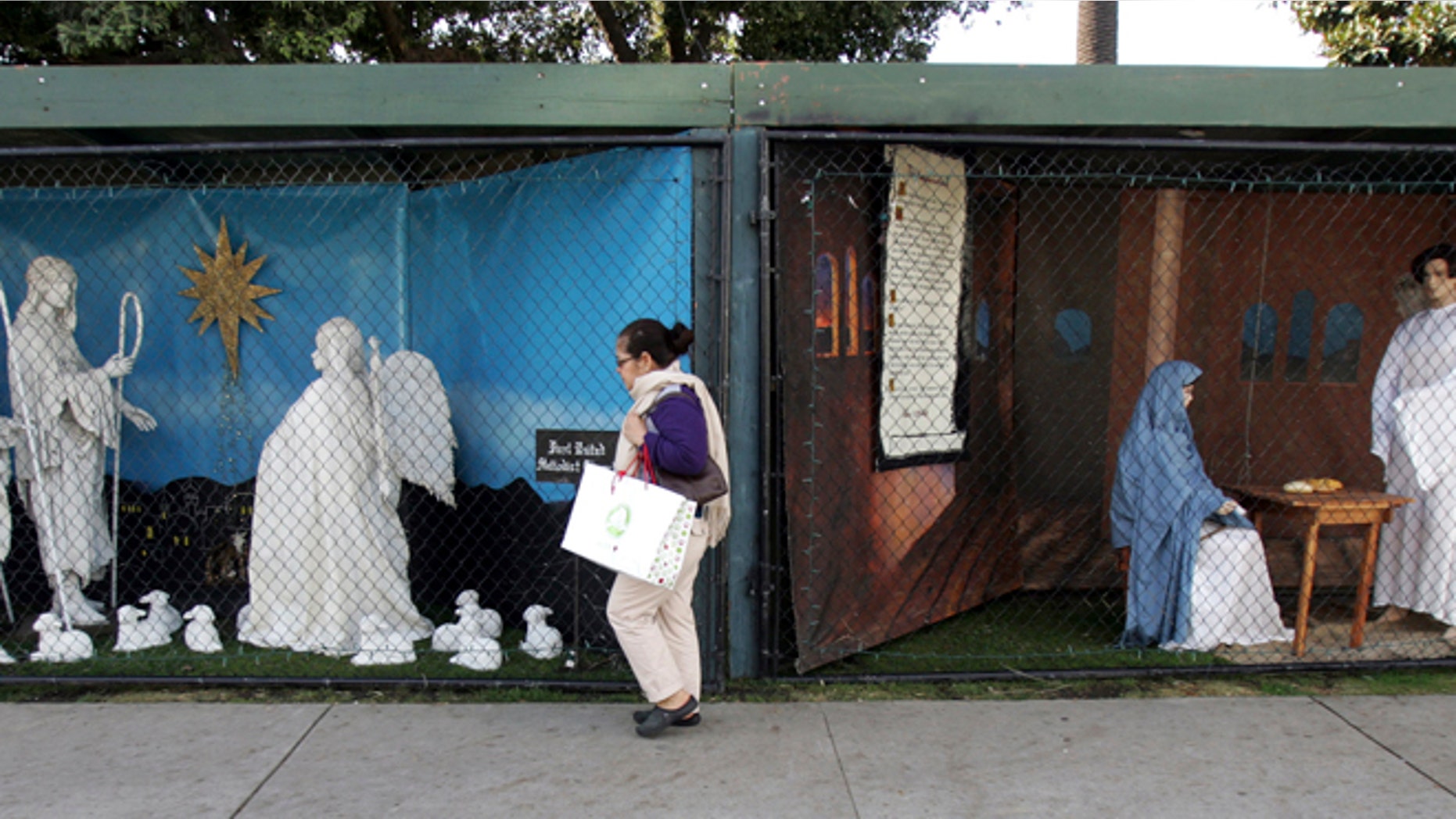 Dec. 13, 2011: A woman walks past a two of the traditional displays showing the Nativity scene along Ocean Avenue at Palisades Park in Santa Monica, Calif.