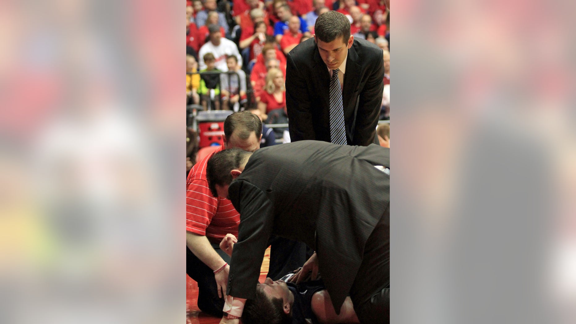 Butler head coach Brad Stevens looks on as his trainers attend to Rotnei Clarke after Clarke was injured during the first half of an NCAA college basketball game against Dayton, Saturday, Jan. 12, 2013, in Dayton, Ohio. Clarke was taken from the arena on a backboard.(AP Photo/Skip Peterson)