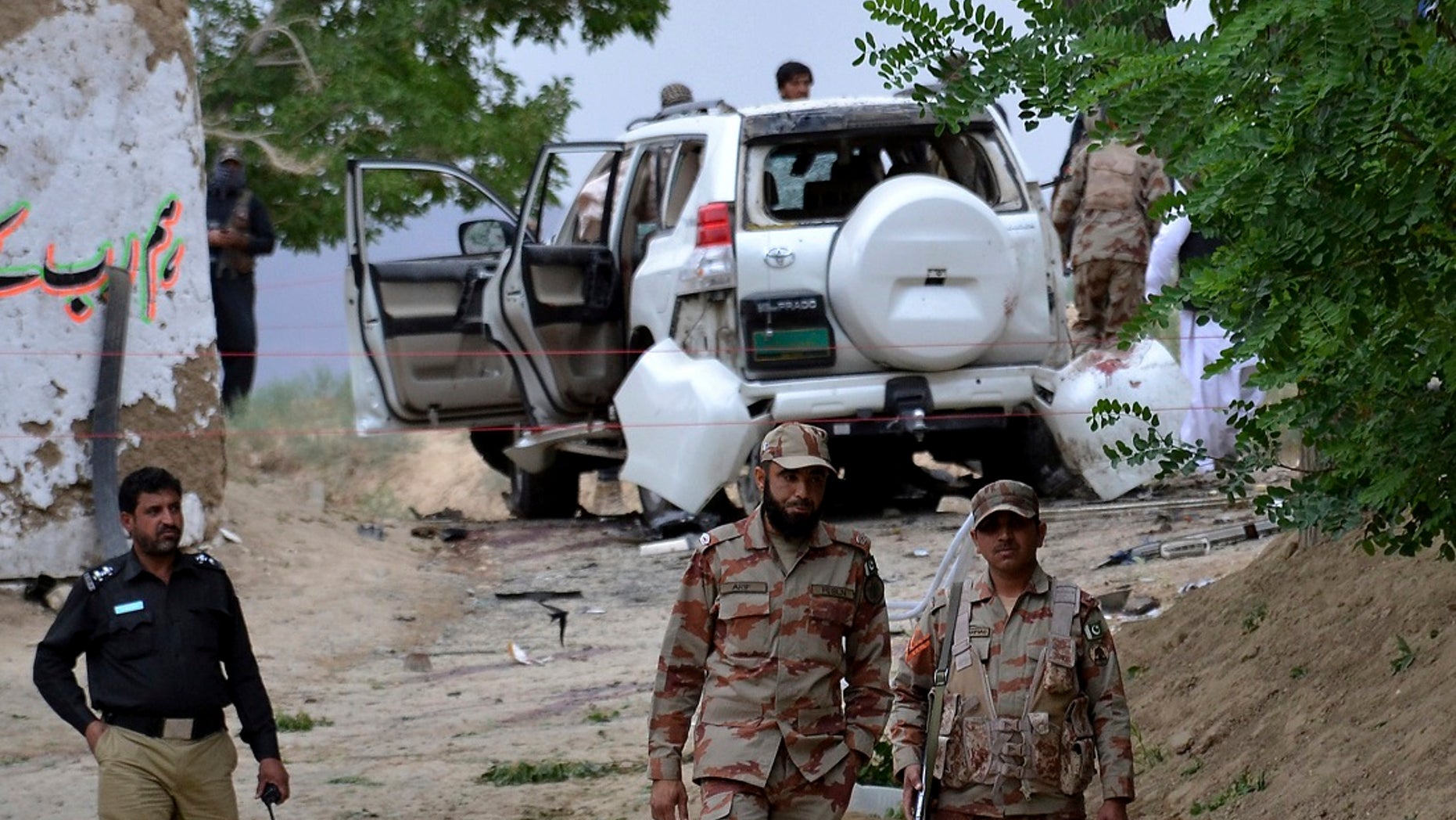 Pakistani security officials stand guard at the site of a suicide bombing which killed dozens of people and left many injured in Mastung district near Quetta, Pakistan, Friday, May 12, 2017. (AP Photo/Arshad Butt)