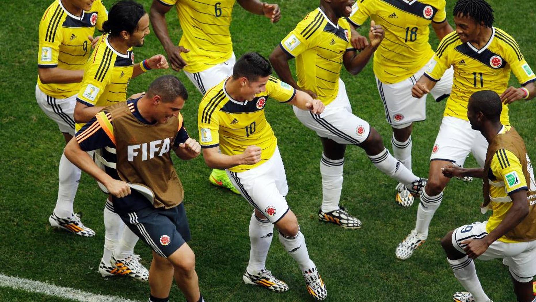 FILE - In this June 19, 2014, file photo, Colombia's James Rodriguez, center, dances with teammates in celebration after scoring during the group C World Cup soccer match between Colombia and Ivory Coast at the Estadio Nacional in Brasilia, Brazil. The euphoria in soccer-mad Colombia is deafening, and wonderfully contagious, ahead of Friday’s do-or-die World Cup match against host Brazil. Not since Colombia drubbed Argentina 5-0 in a 1993 World Cup qualifier has the South American nation of 48 million been so enthralled by the beautiful game. (AP Photo/Themba Hadebe, File)