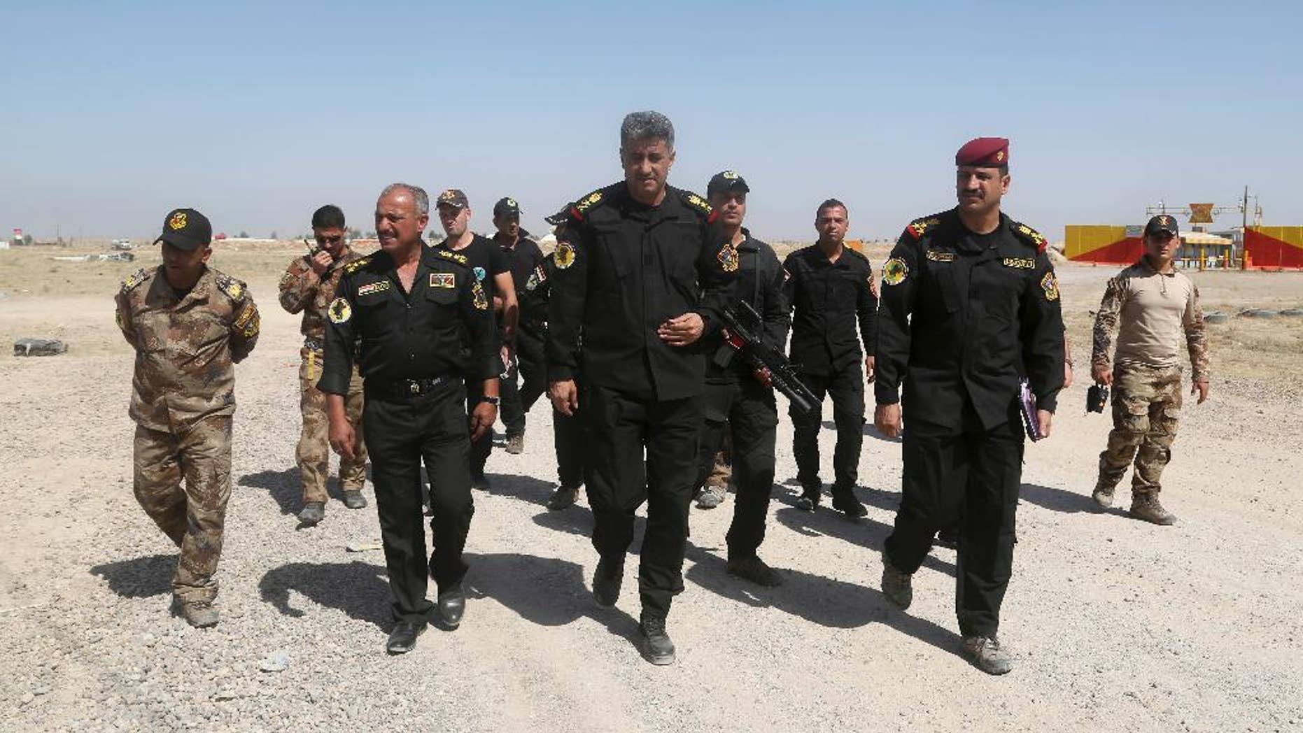 Commander of the Fallujah operation, Lt. General Abdul-Wahab al-Saadi, center, inspects his forces ahead of an operation to re-take the Islamic State-held City of Fallujah, outside Fallujah, Iraq, Sunday, May 29, 2016. Teaming up with paramilitary troops and backed by aerial support from the U.S.-led coalition, Iraqi government launched a large-scale offensive to dislodge IS militants from the city of Fallujah, one of the last major IS strongholds in Iraq located about 40 miles (65 kilometers) west of Baghdad. (AP Photo/Khalid Mohammed)