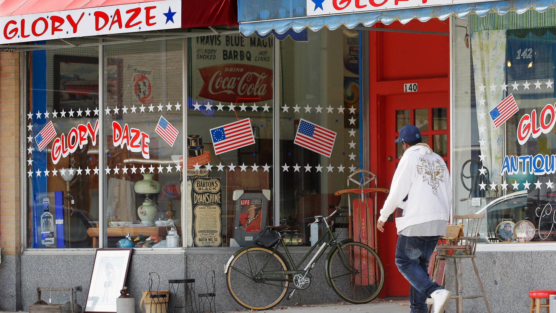 In this Oct. 23, 2014 photo, people walk past one of the popular businesses in downtown in Danville, Ill., where there still are many vacant buildings. Many young people have moved away as manufacturers that provided thousands of well-paying, middle class jobs have closed, but the city is working to attract new businesses and give residents a reason to stay. (AP Photo/Seth Perlman)