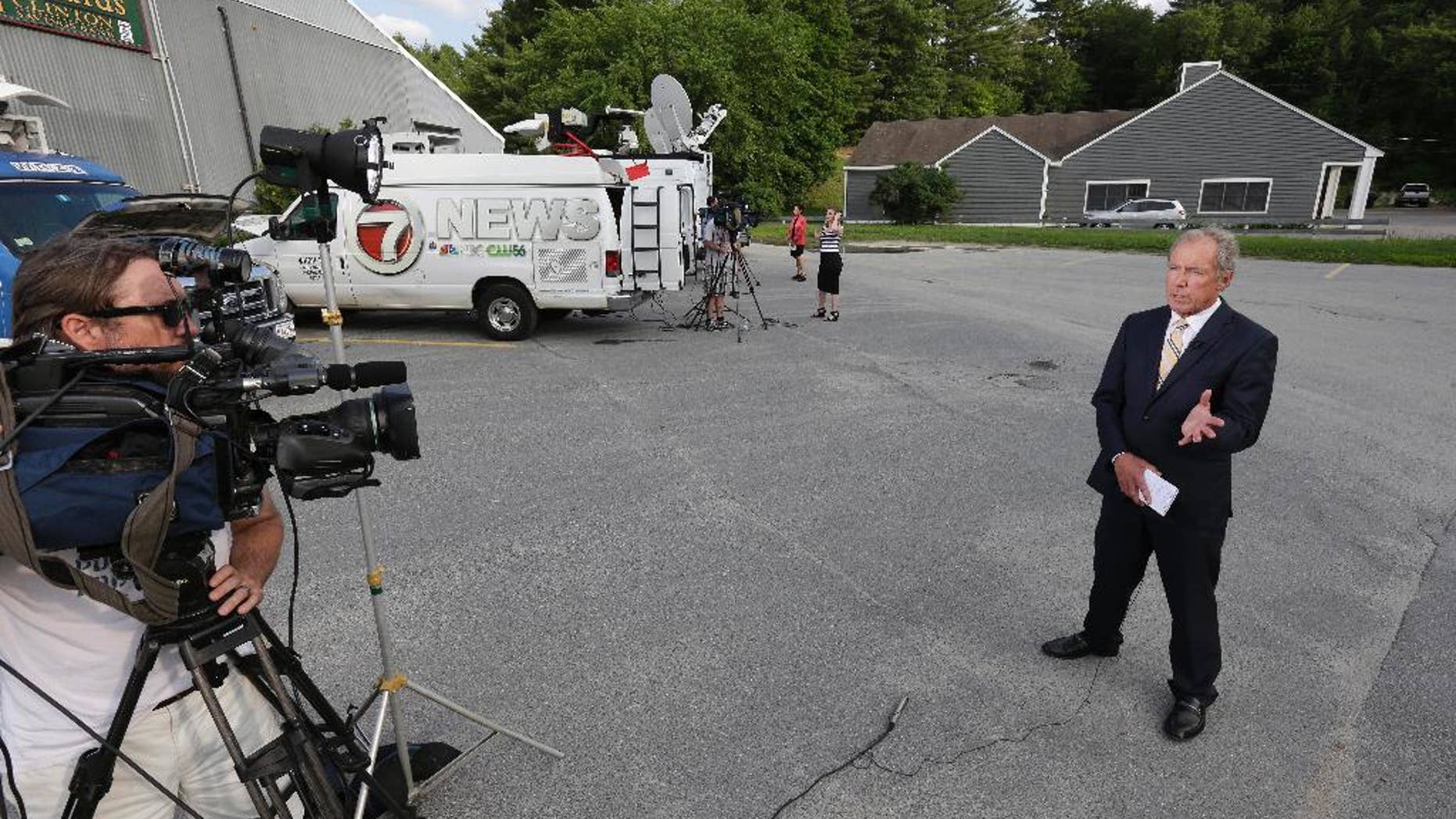 Television news crews gather Wednesday, June 10, 2015, near a business in Bolton, Mass., The business belonging to relatives of Keith Broomfield, an American fighting with Kurdish forces against the Islamic State group in Syria has been killed in battle, authorities said Wednesday, likely the first U.S. citizen to die fighting alongside them against the extremists. (AP Photo/Steven Senne)