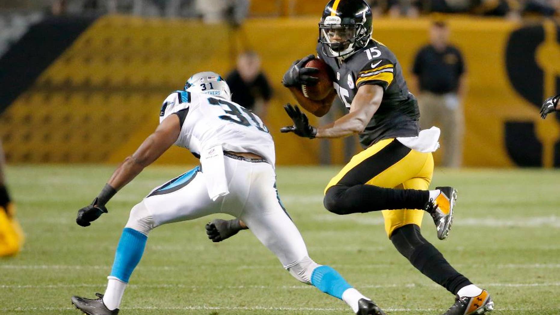 Pittsburgh Steelers wide receiver Justin Brown (15) tries to evade Carolina Panthers defensive back James Dockery (31) in the second quarter of a NFL preseason football game on Thursday, Aug. 28, 2014 in Pittsburgh. (AP Photo/Gene Puskar)