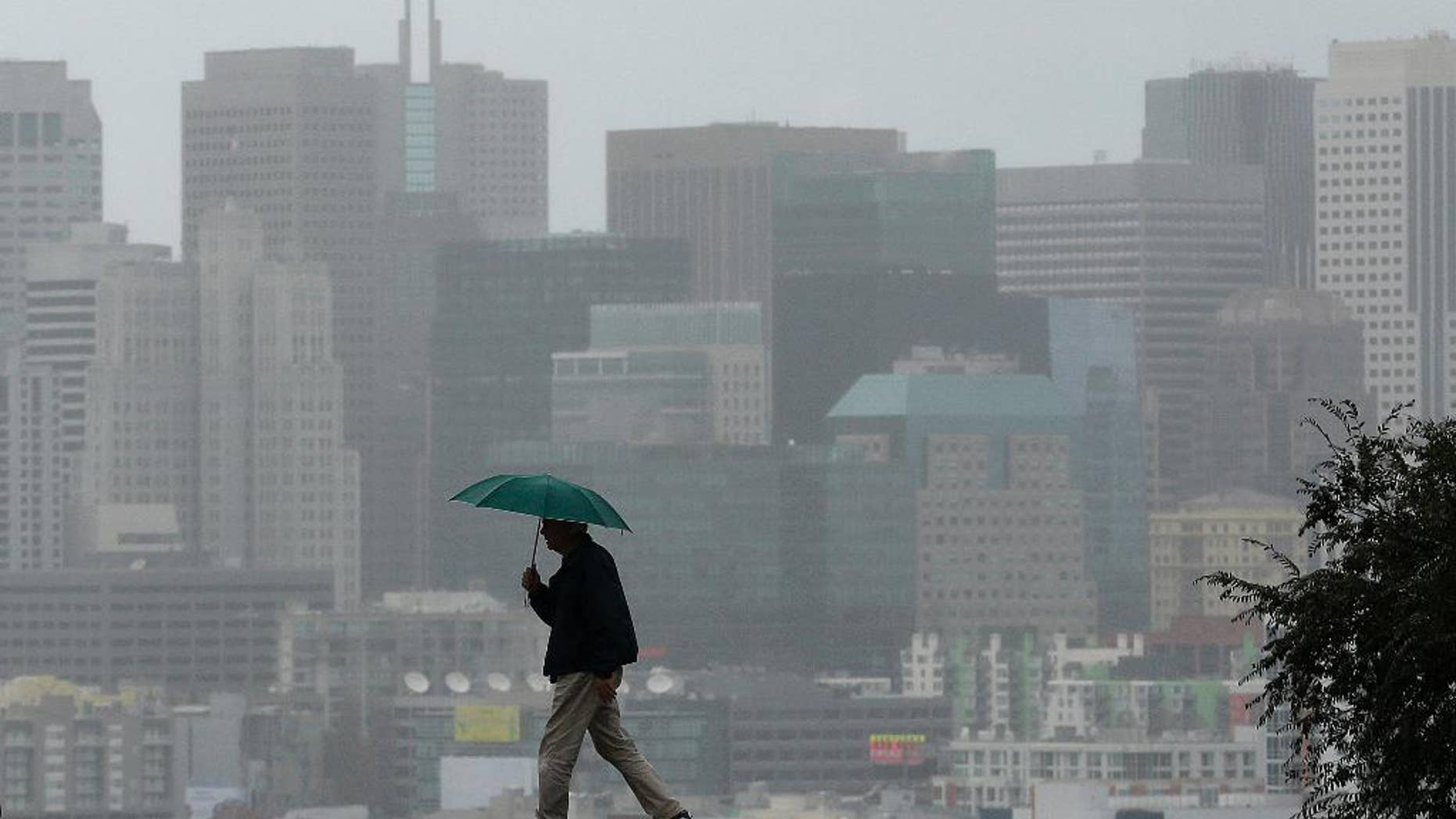 FILE - In this Tuesday, Jan. 5, 2016 file photo, Richard Polich holds an umbrella as he crosses a street in the rain in San Francisco. Taking a regional approach to saving water in California’s drought, state regulators may propose relaxing conservation orders for El Nino-soaked Northern Californians, while keeping in place more strict rules for residents of the drier Southern California. (AP Photo/Jeff Chiu)