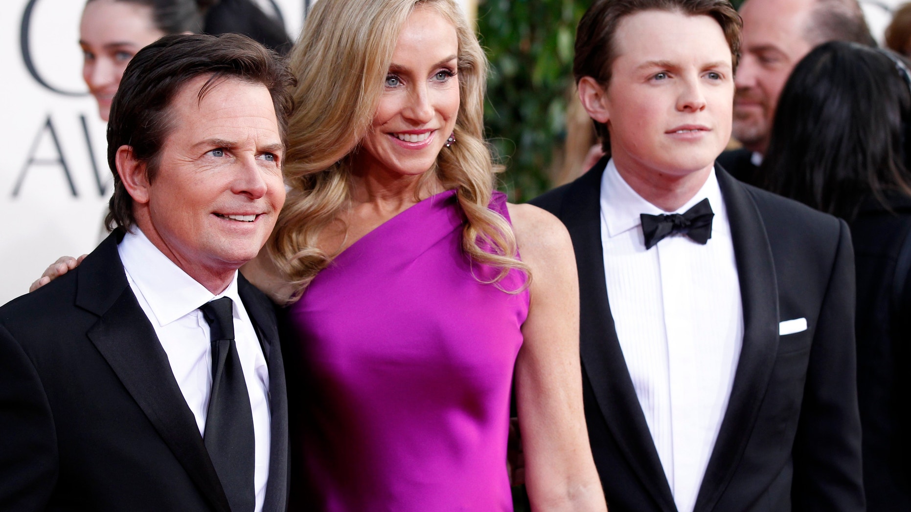 Actor Michael J. Fox, his wife Tracy Pollan and their son Sam Fox (R) arrive at the 70th annual Golden Globe Awards in Beverly Hills, California, January 13, 2013.