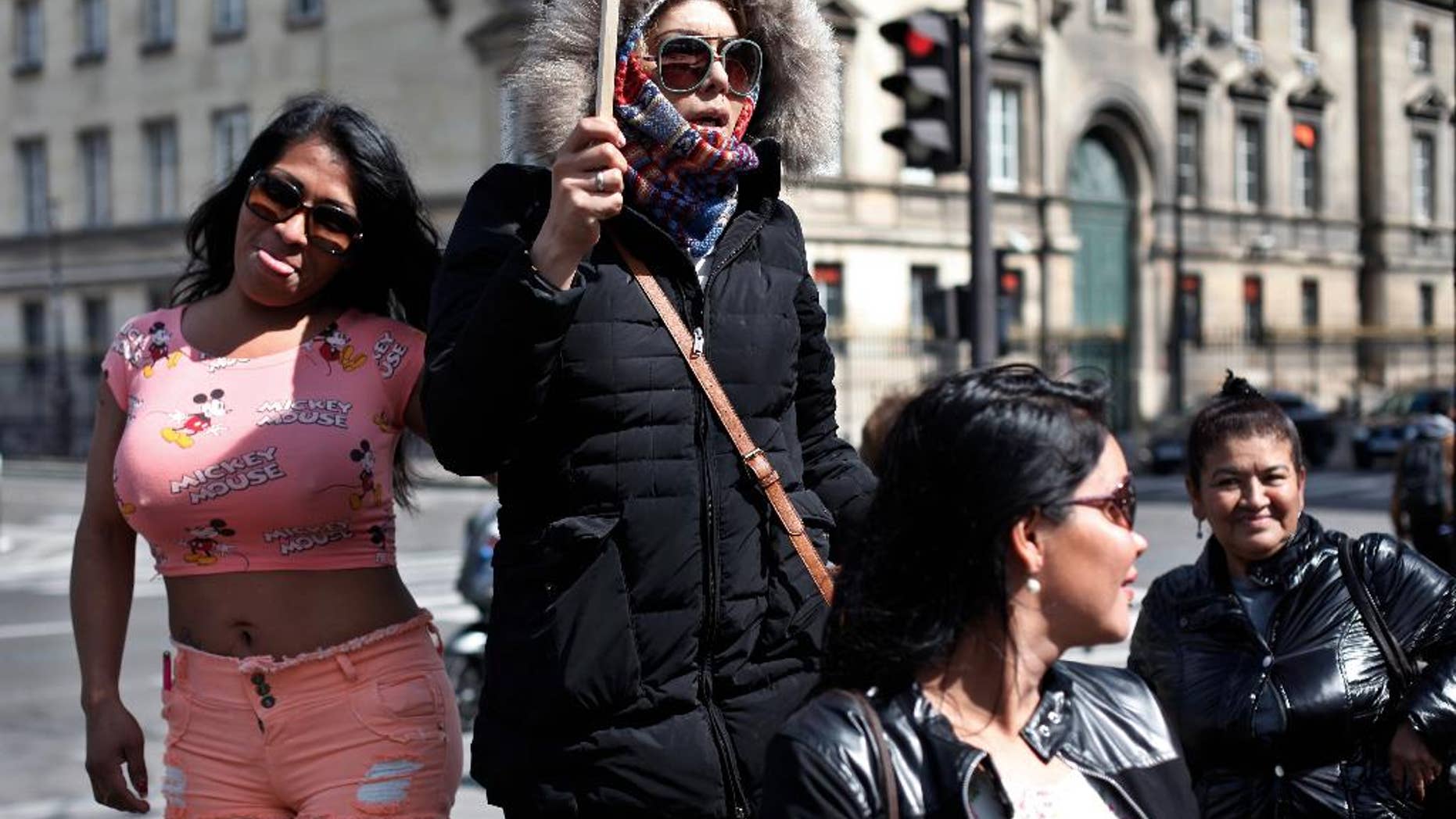 Sex workers hold signs during a protest against new bill against prostitution and sex trafficking, in Paris, Wednesday, April 6, 2016. France's lower house of parliament holds a final vote on Wednesday on a bill against prostitution and sex trafficking that bans buying sex, not selling it. Customers would face fines and be required to attend classes on the harms of prostitution. Opponents fear that cracking down will push prostitutes to hide and they would be even more at the mercy of pimps and violent clients. (AP Photo/Thibault Camus)