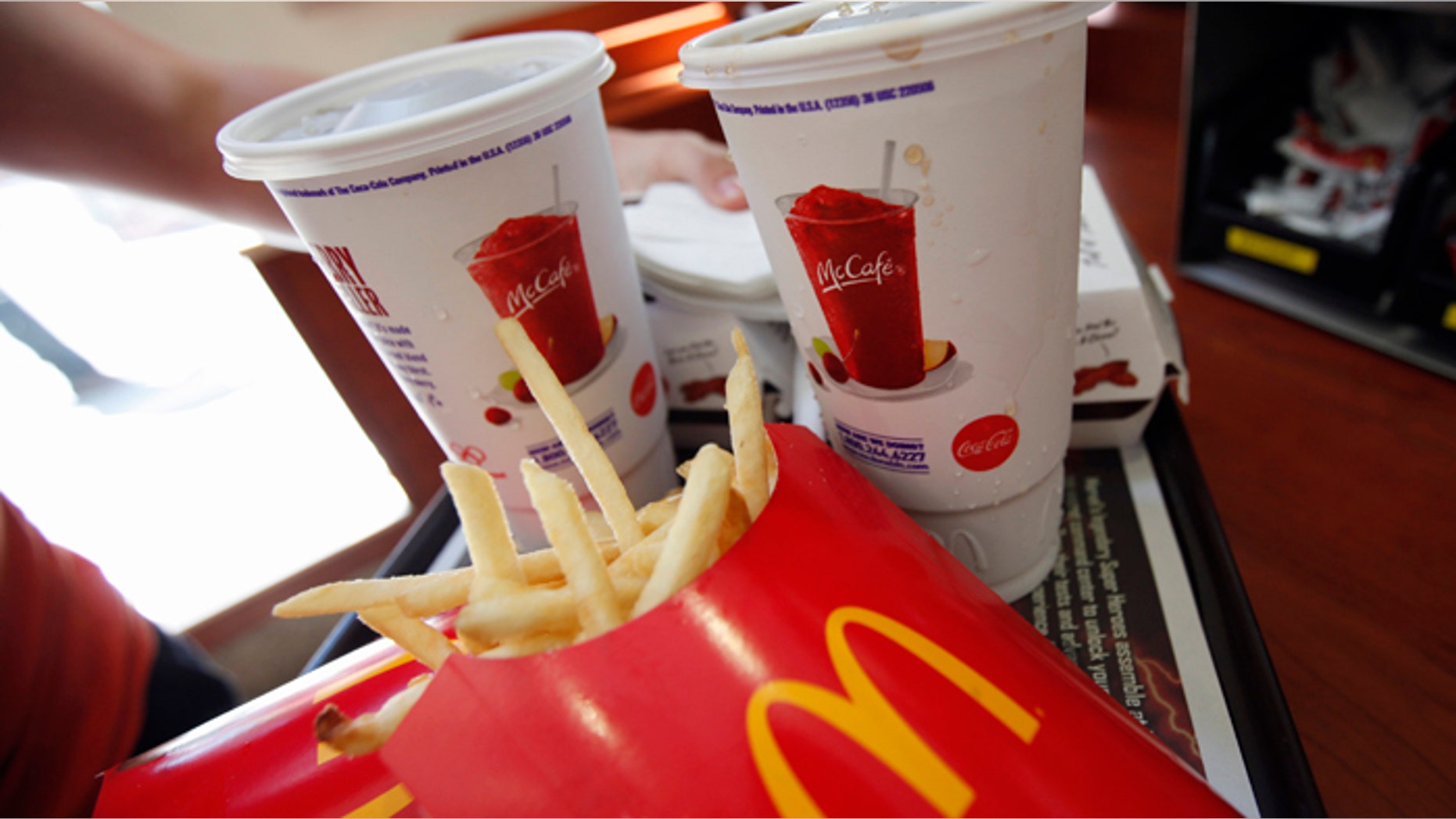 A man holds a tray of food at a McDonald's restaurant in Times Square, New York in this May 31, 2012 file photo. REUTERS/Mike Segar/Files (UNITED STATES - Tags: POLITICS FOOD BUSINESS) - RTR3ASGS