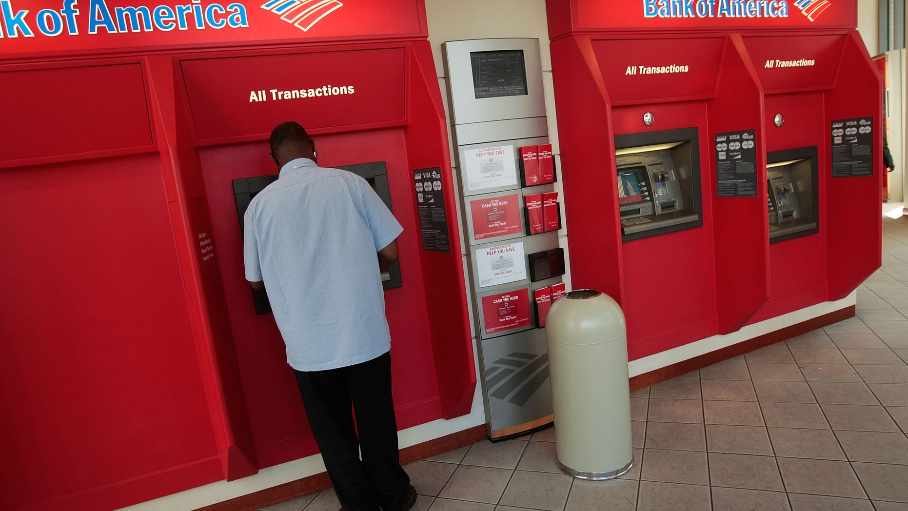 NEW YORK - JULY 21: A man operates an automated teller machine at a Bank of America branch bank in midtown Manhattan July 21, 2008 in New York City. Bank of America Corp. reported falling profits of 41-percent to $3.41 billion in their second quarter earnings but nonetheless beating analysts' 54-percent estimates, sending their stock price higher to $30.24 a share in morning trading. (Photo by Chris Hondros/Getty Images)