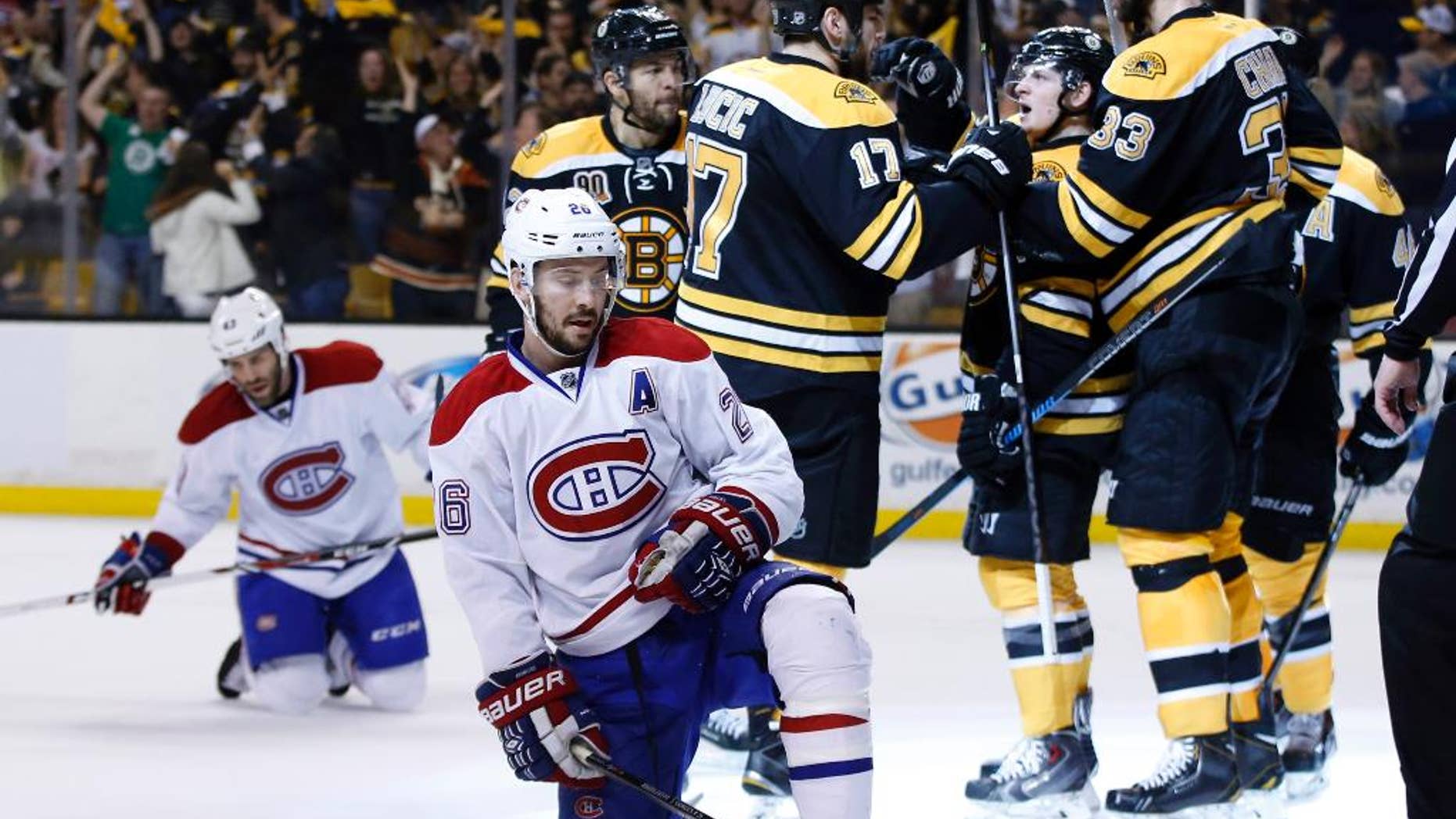 Montreal Canadiens defensemen Josh Gorges (26) and Mike Weaver, left, react as Boston Bruins defenseman Zdeno Chara (33), defenseman Torey Krug (47) and left wing Milan Lucic (17) celebrate a goal by right wing Jarome Iginla, left, during the second period in Game 7 of an NHL hockey second-round playoff series in Boston, Wednesday, May 14, 2014. (AP Photo/Elise Amendola)