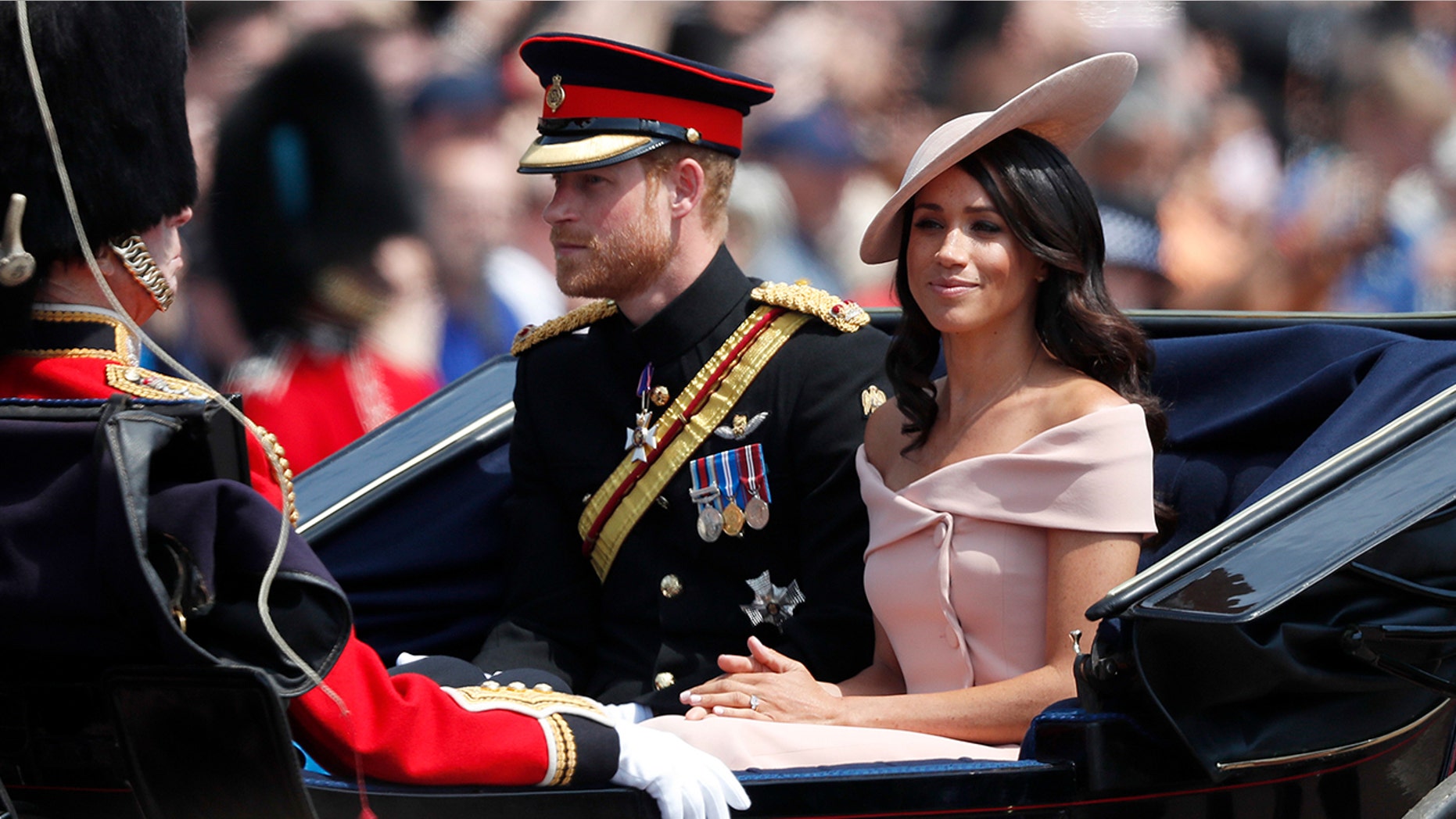 Britain's Prince Harry, left, and Meghan, Duchess of Sussex ride in a carriage to attend the annual Trooping the Colour Ceremony in London, Saturday, June 9, 2018.
