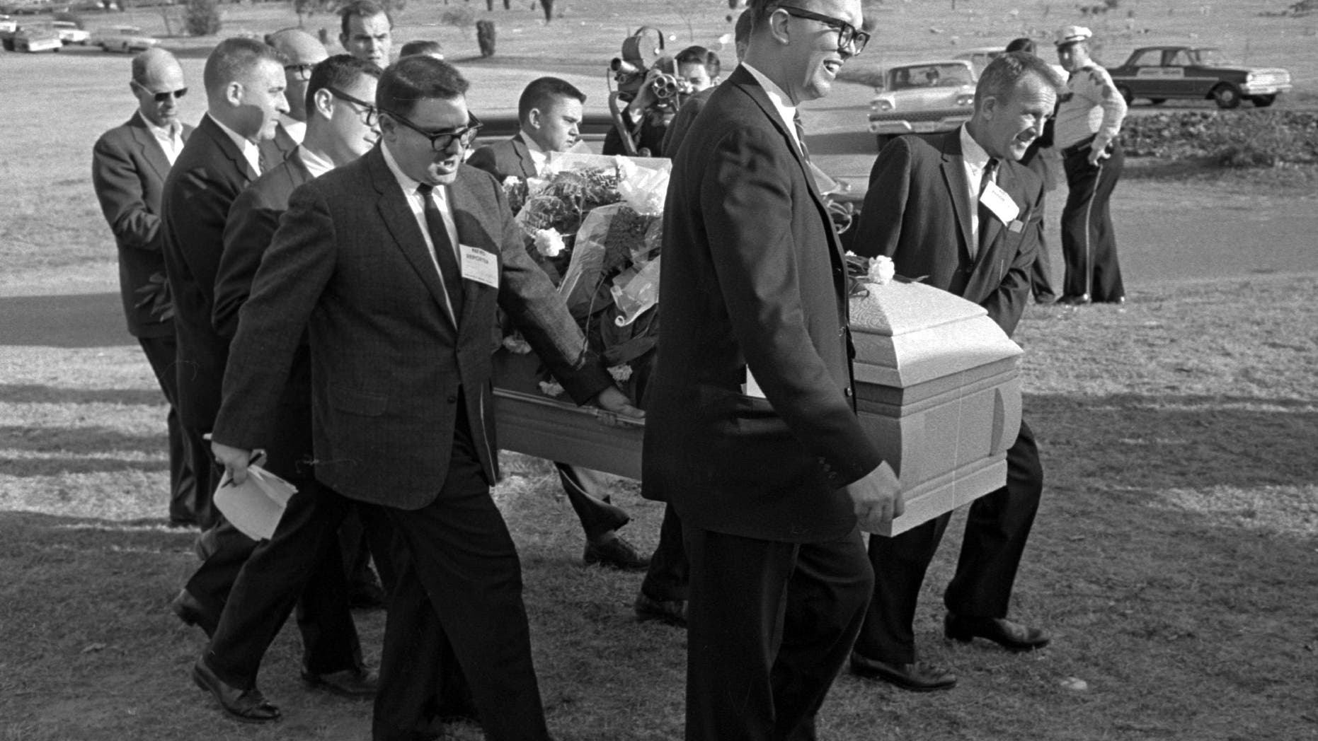 Reporters were enlisted to act as pall bearers at the interment of Lee Harvey Oswald at the Shannon Rose Hill Cemetery. Pallbearers from left end - Jerry Flemmons with crewcut and no glasses. In front of Flemmons are reporters Ed Horn and Mike Cochran. Funeral director Paul J. Groody was among the pallbearers. On the far side of the casket are Jon McConal, rear, and Preston McGraw, front. The pallbearer obscured behind Groody could not be identified. (AP Photo/Gene Gordon)