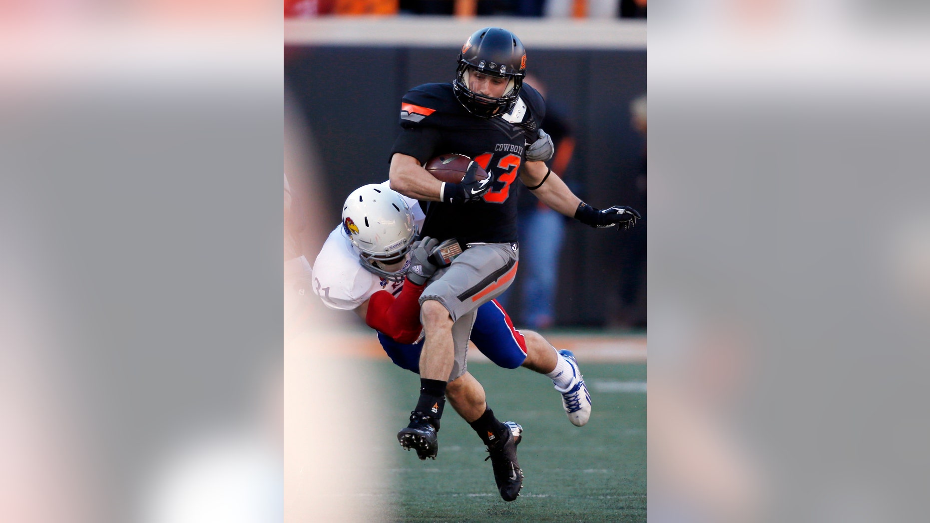 Oklahoma State wide receiver David Glidden (13) is tackled by Kansas defender Ben Heeney (31) in the first quarter of an NCAA college football game in Stillwater, Okla., Saturday, Nov. 9, 2013. (AP Photo/Sue Ogrocki)