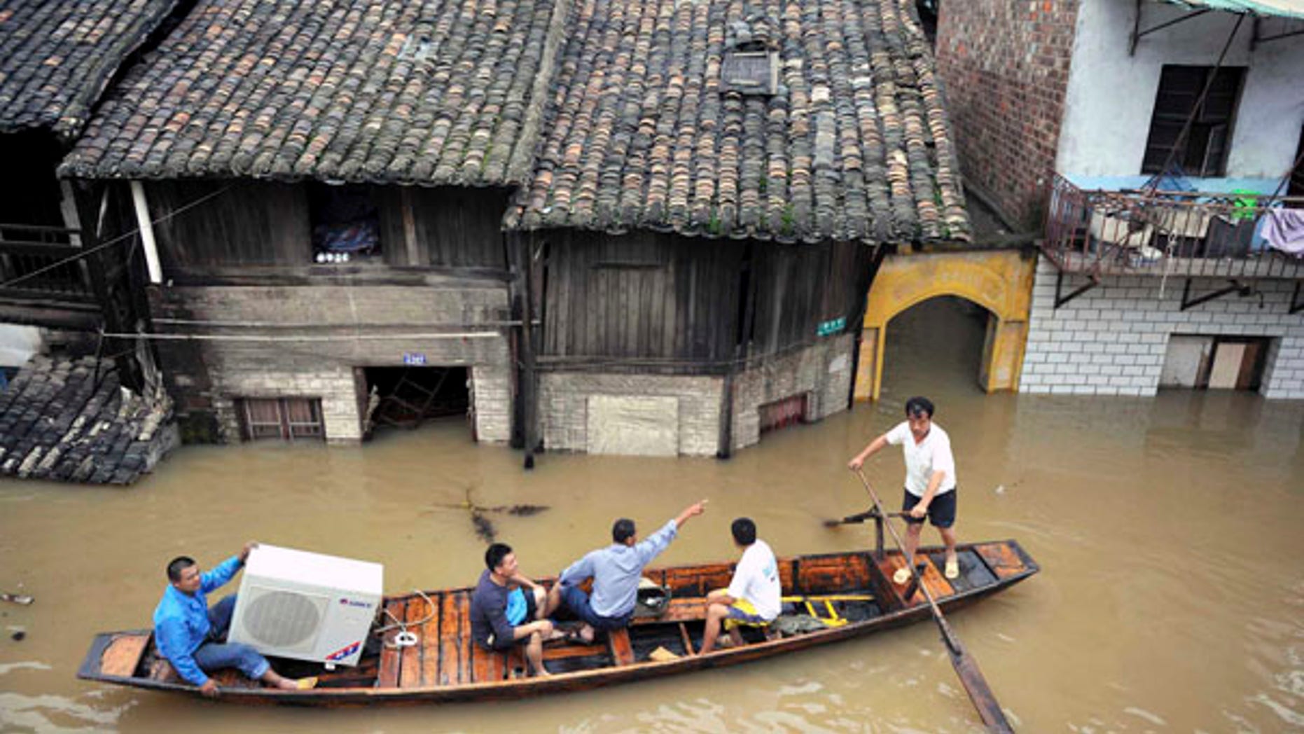 June 24: Llocal residents transfer their belongings on a boat in Xiangtan county, in central China's Hunan province.