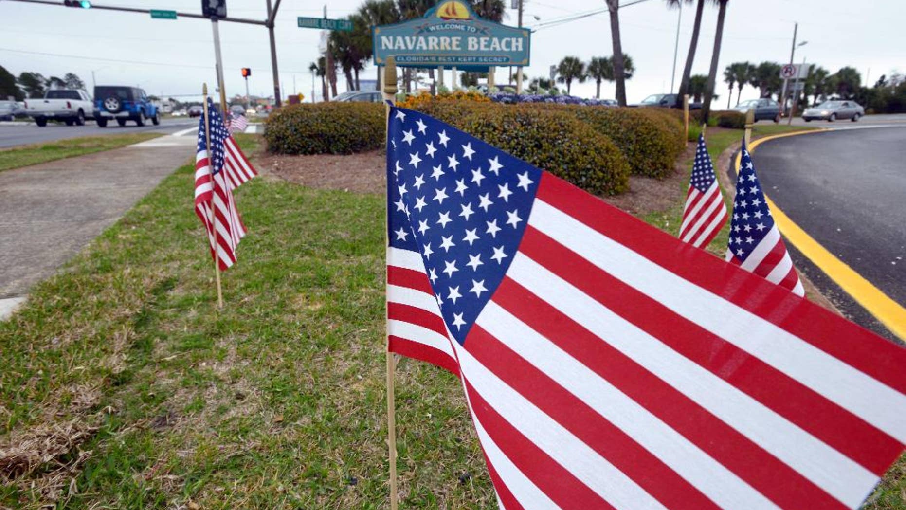 American flags stand in the median near the bridge entrance to Navarre Beach, Fla., Thursday, March 12, 2015. There's been an outpouring of support in this heavily military community following the crash of an Army Black Hawk helicopter Tuesday evening. In various parts of Navarre, 11 flags are placed, one one for each of the servicemen missing in the crash. (AP Photo/Northwest Florida Daily News, Devon Ravine)