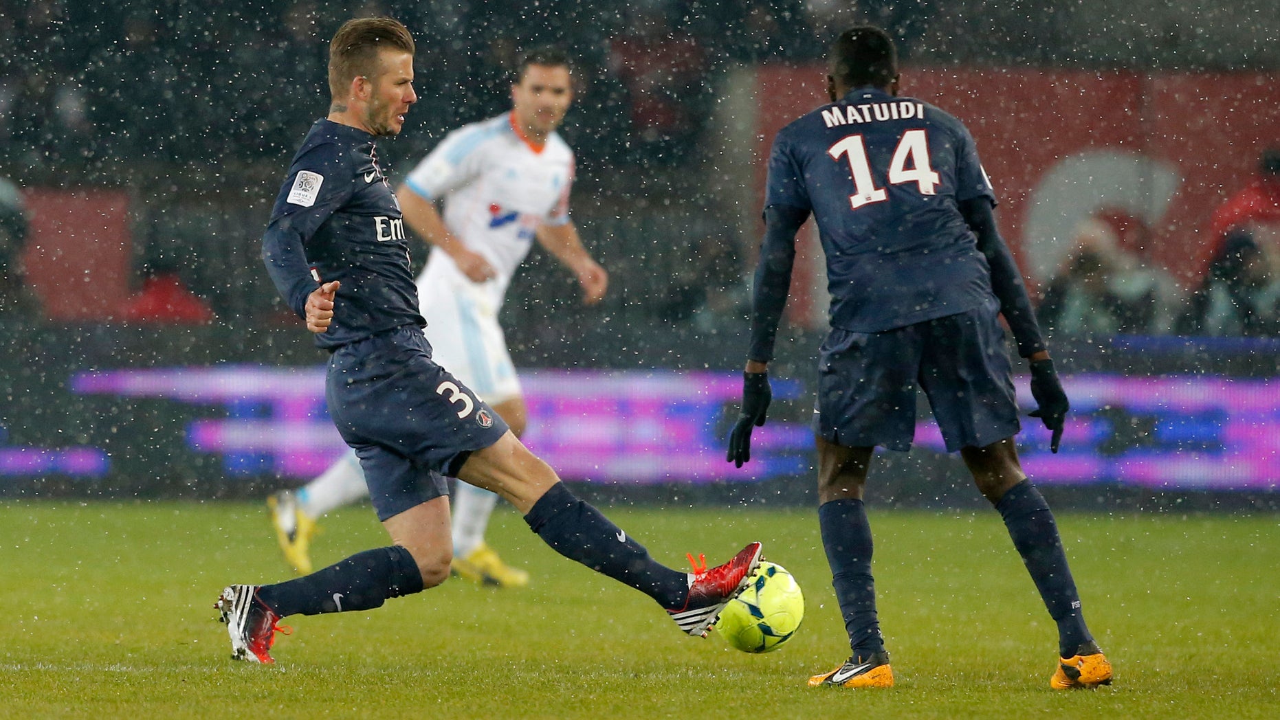 Paris Saint Germain's David Beckham, left, runs with the ball during the League One soccer match between PSG and Marseille at Parc des Princes Stadium, in Paris, Sunday Feb. 24, 2013. Beckham made his Paris St Germain debut as Carlo Ancelotti's men took a potentially vital step towards claiming the Ligue 1 title. (AP Photo/Francois Mori)