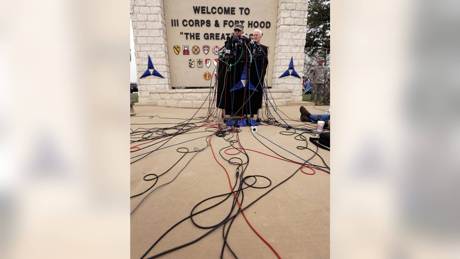 Lt. Gen. Mark Milley, left,and U.S. Sen. John Cornyn, right, talk to the media near Fort Hood's main gate, Thursday, April 3, 2014, in Fort Hood, Texas. A soldier opened fire Wednesday on fellow service members at the Fort Hood military base, killing three people and wounding 16 before committing suicide. (AP Photo/Eric Gay)