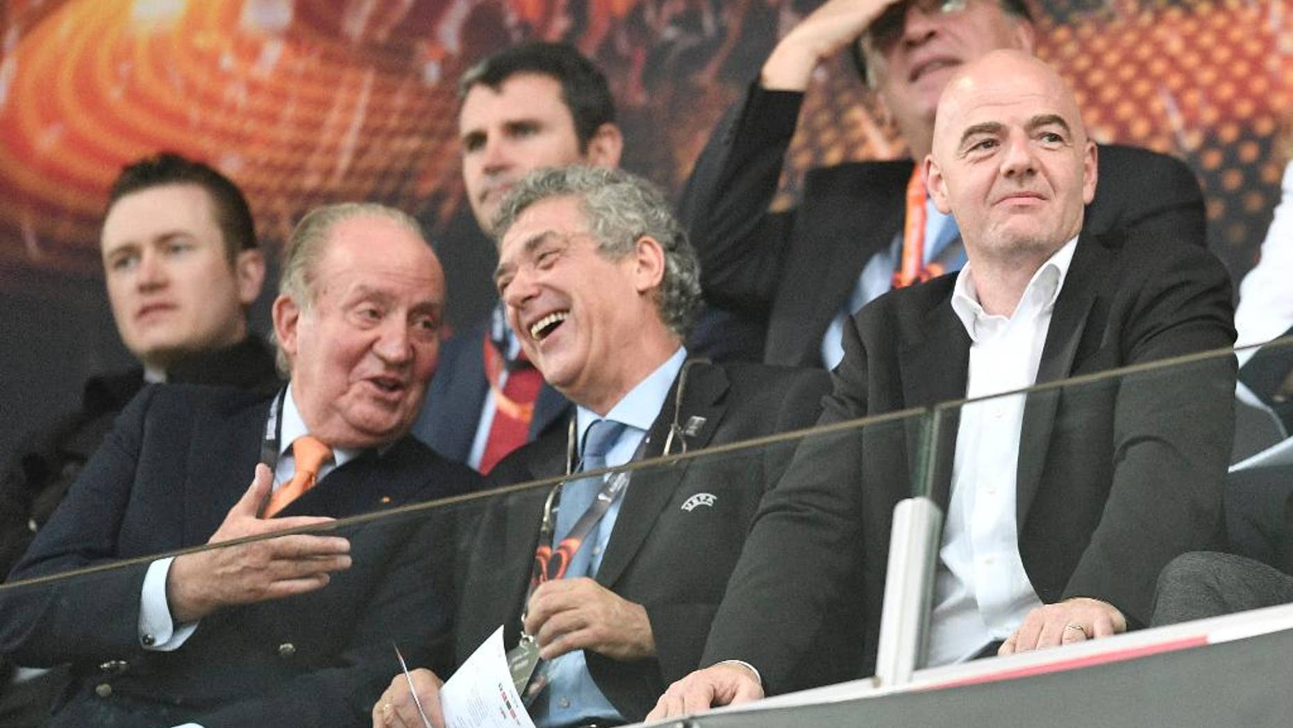 Former King Juan Carlos I of Spain, left, and FIFA president, Gianni Infantino, right, laugh as they wait for the start of the Europa League final soccer match between Liverpool and Sevilla in Basel, Switzerland, Wednesday, May 18, 2016. (AP Photo/Martin Meissner)