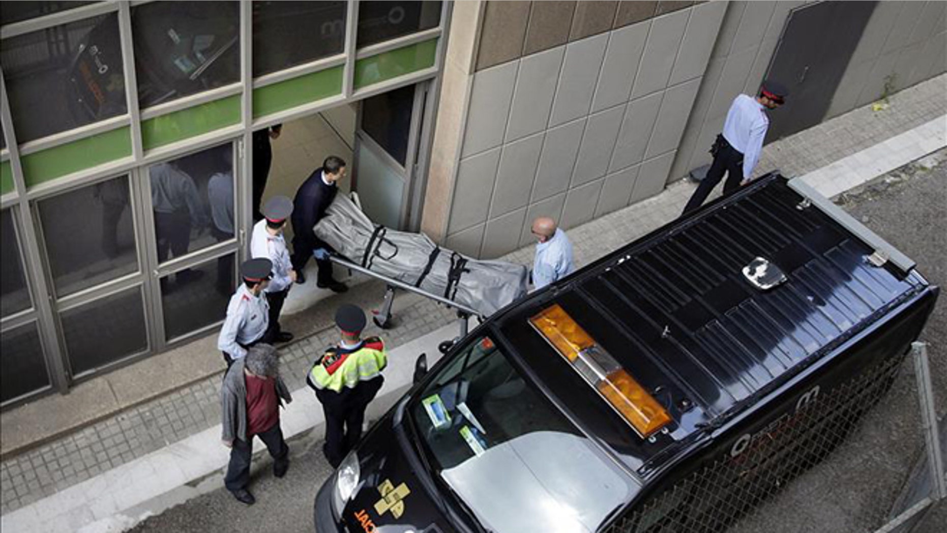 Coroner's office personnel remove the body of IES teacher Joan Fuster from the Barcelona school where a student opened fire on Monday, killing Fuster and injuring four others. (Photo: EFE)