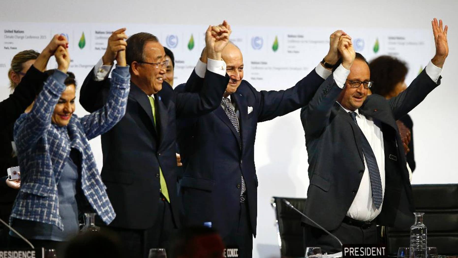 FILE - In this Dec. 12, 2015, file photo, French President Francois Hollande, right, French Foreign Minister and president of the COP21 Laurent Fabius, second right, United Nations climate chief Christiana Figueres, left, and United Nations Secretary General Ban Ki-moon hold their hands up in celebration after the final conference at the COP21, the United Nations conference on climate change, in Le Bourget, north of Paris. A team of top scientists are telling world leaders to stop congratulating themselves for a Paris agreement to fight climate change because if more isn’t done the world will likely hit the agreed-upon dangerous warming level in about 35 years. (AP Photo/Francois Mori, File)