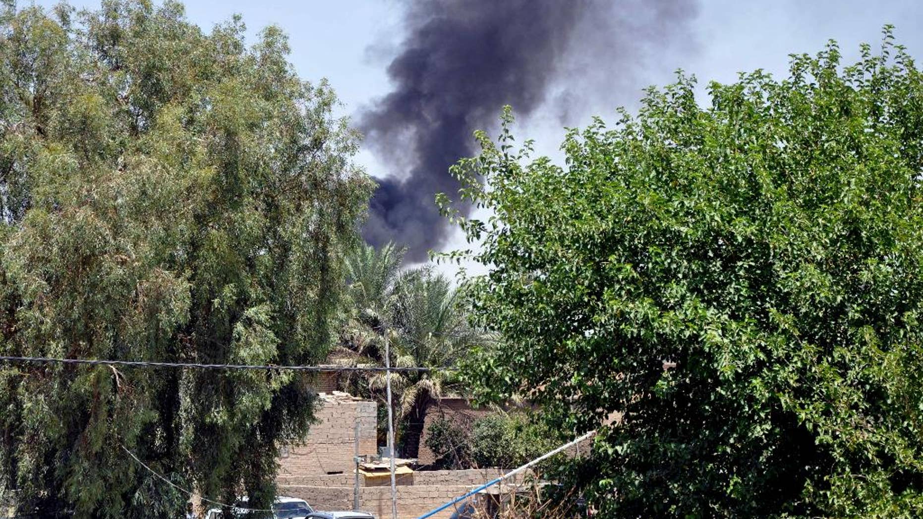 In this photo taken on Saturday, June 28, 2014, smoke rises during a military operation to regain control of Dallah Abbas north of Baqouba, the capital of Iraq's Diyala province, 35 miles (60 kilometers) northeast of Baghdad, Iraq. The Islamic State in Iraq and the Levant which already controls vast swaths in northern and eastern Syria amid the chaos of that nation's civil war, aims to erase the borders of the modern Middle East and impose its strict brand of Shariah law. (AP Photo)